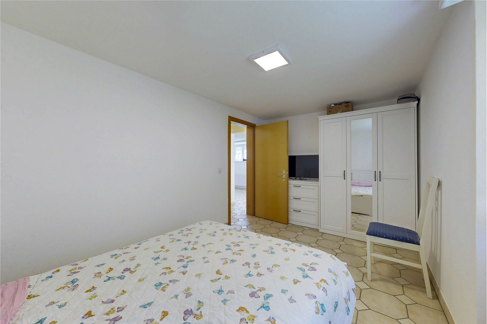 Schlichtes Schlafzimmer mit Schrank und Bett