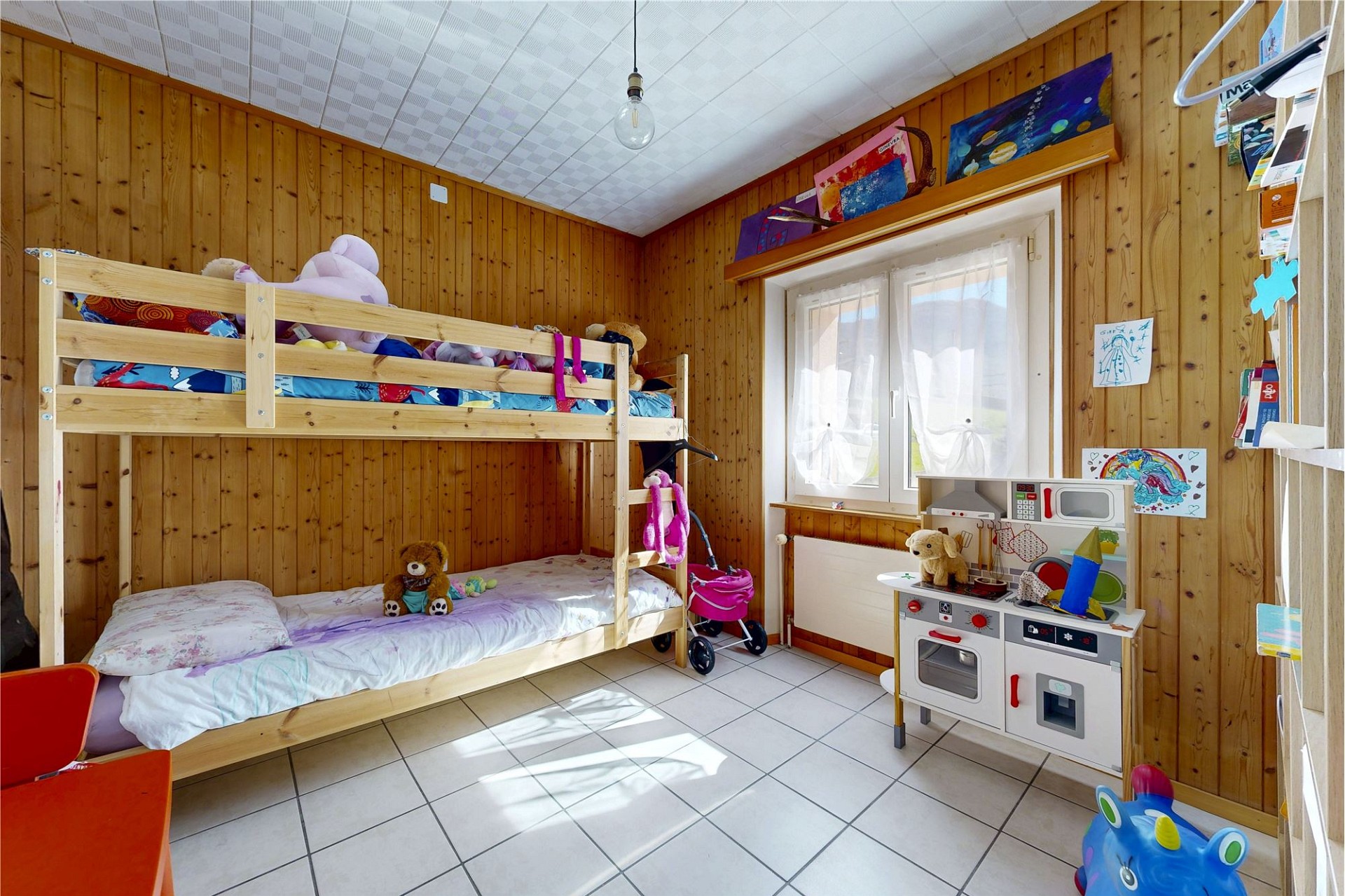 Kinderzimmer mit Etagenbett und Spielbereich
