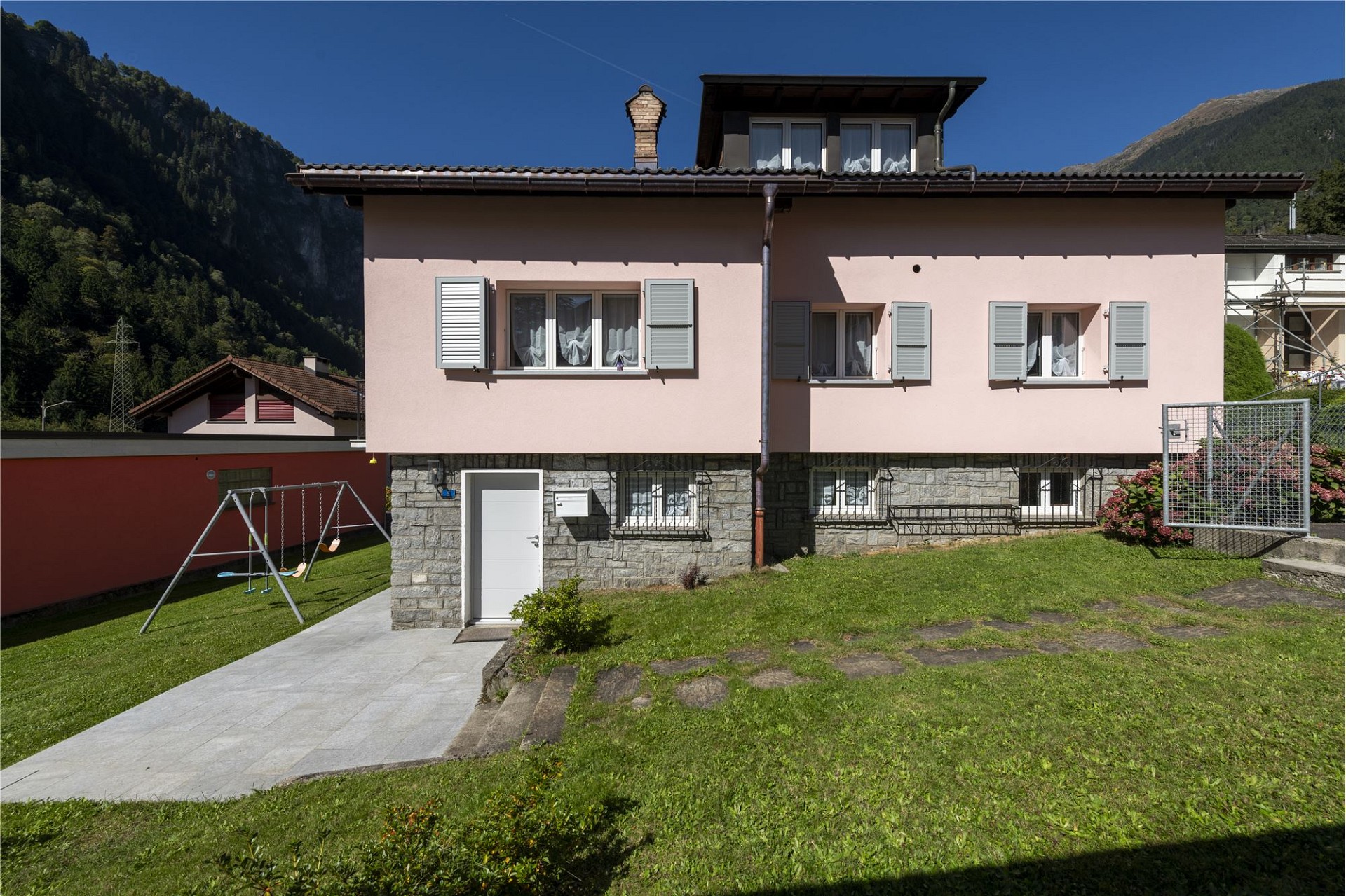 Außenansicht eines Wohnhauses mit Garten und Bergkulisse