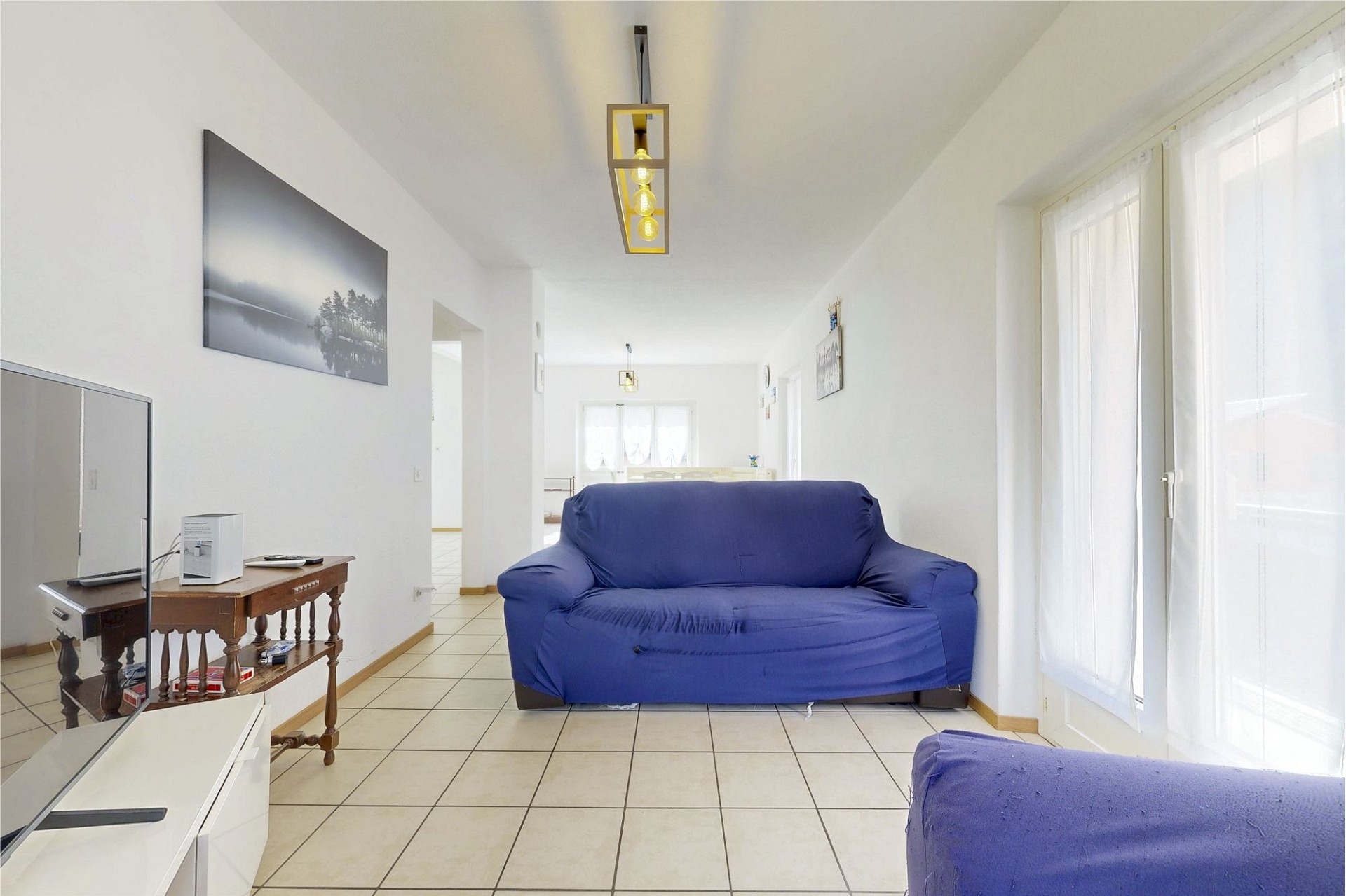 Heller Wohnraum mit Sofa und Fliesenboden