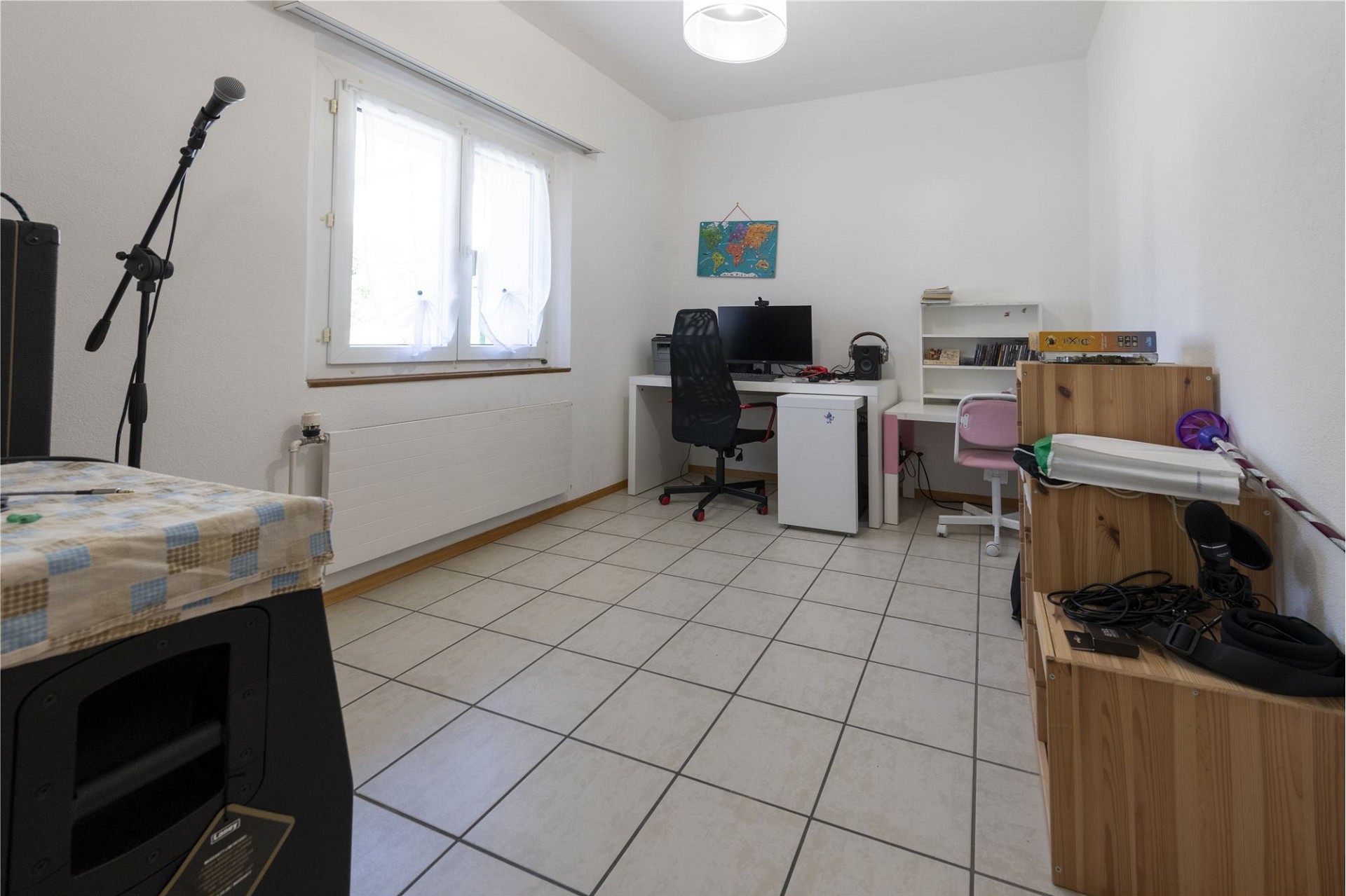 Helles Arbeitszimmer mit Schreibtisch und technischen Geräten