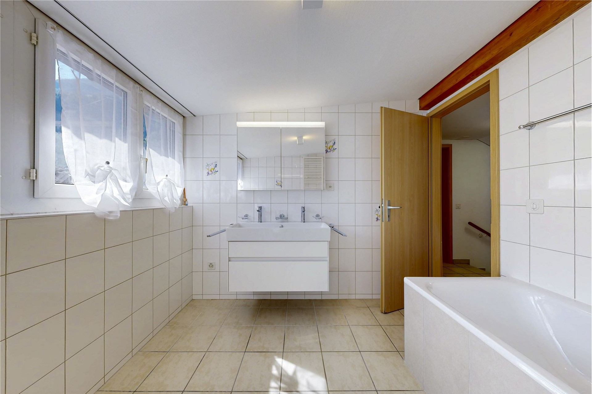 Helles Badezimmer mit Fliesen und Fenster
