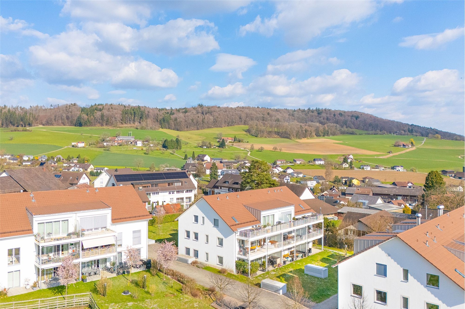 Drohnenaufnahme eines Wohnviertels mit weitem Landschaftsblick