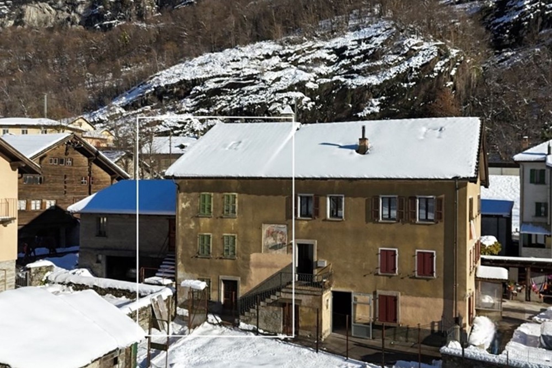Schneebedecktes Dorfhaus am Hang