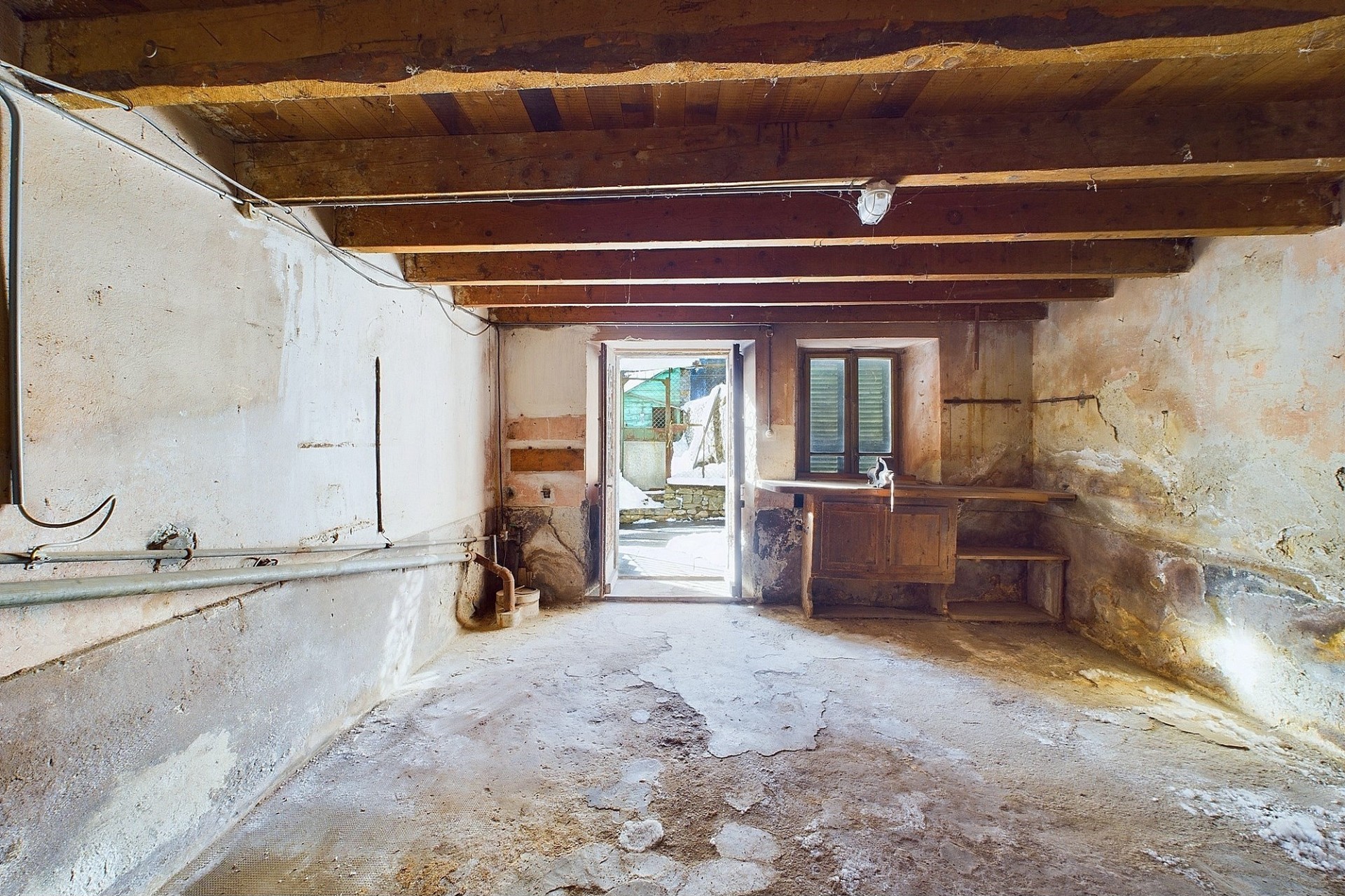 Unrenovierter Kellerraum mit sichtbaren Holzbalken