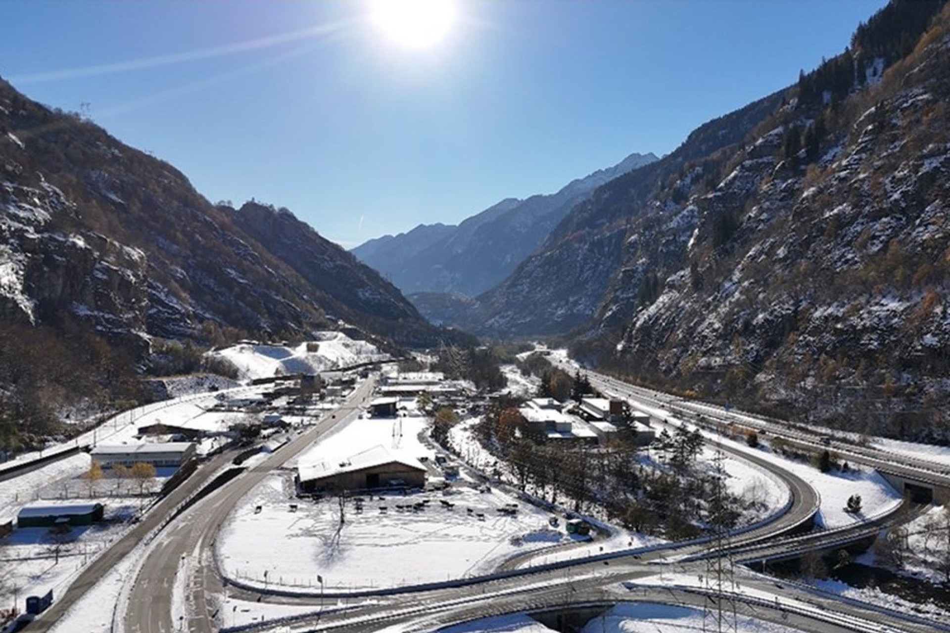 Verschneites Bergtal mit Straßen und Brücken