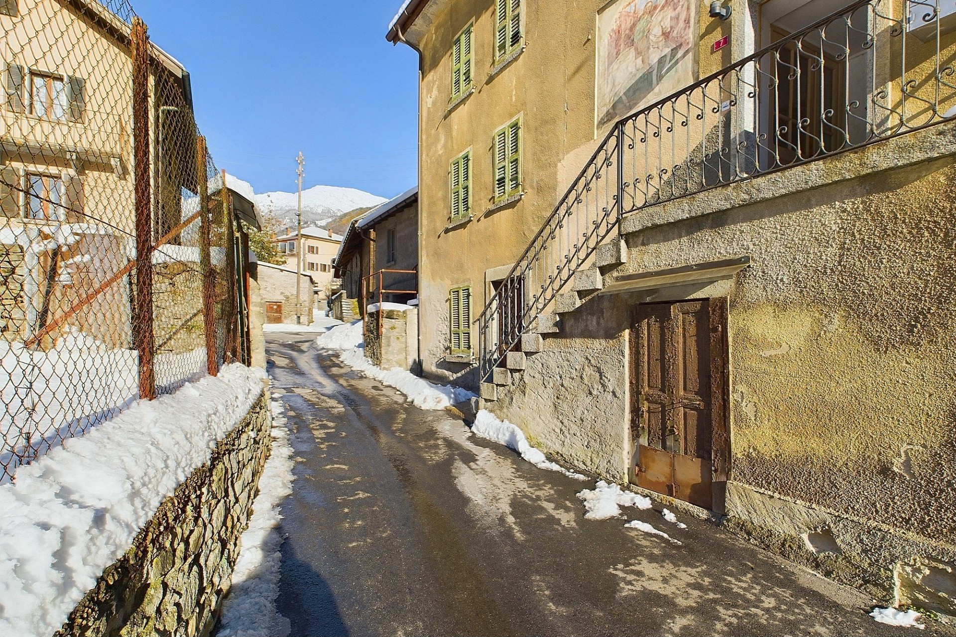 Schmale verschneite Gasse zwischen alten Gebäuden