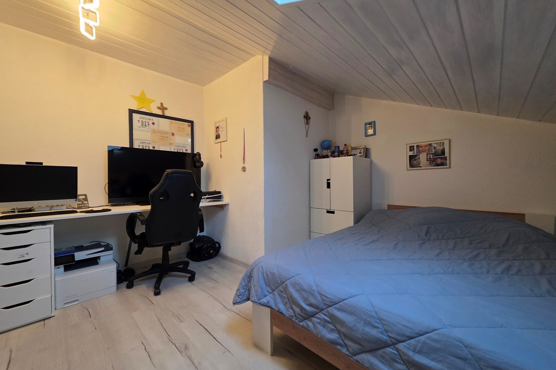 Dachzimmer mit Bett und Arbeitsplatz