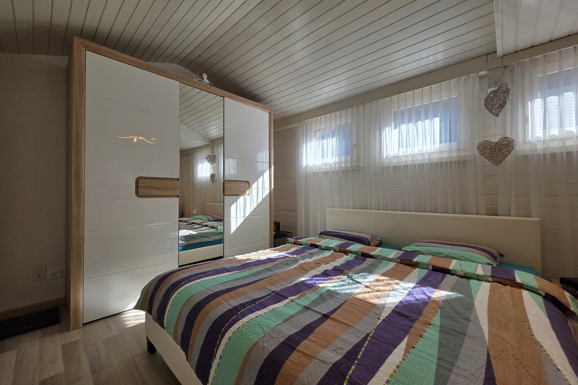Helles Schlafzimmer mit Doppelbett und Kleiderschrank