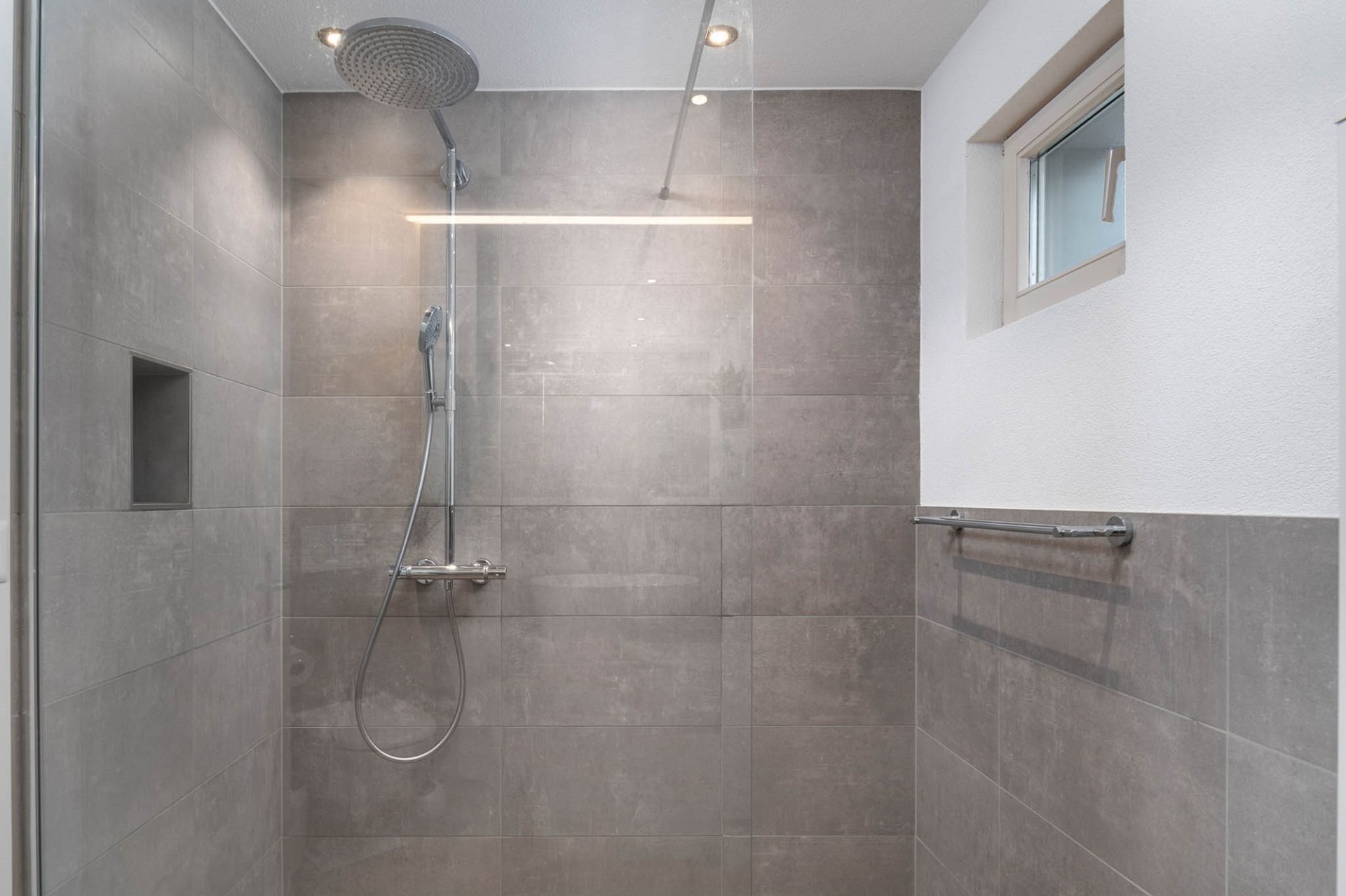 Moderne Dusche mit grauen Fliesen