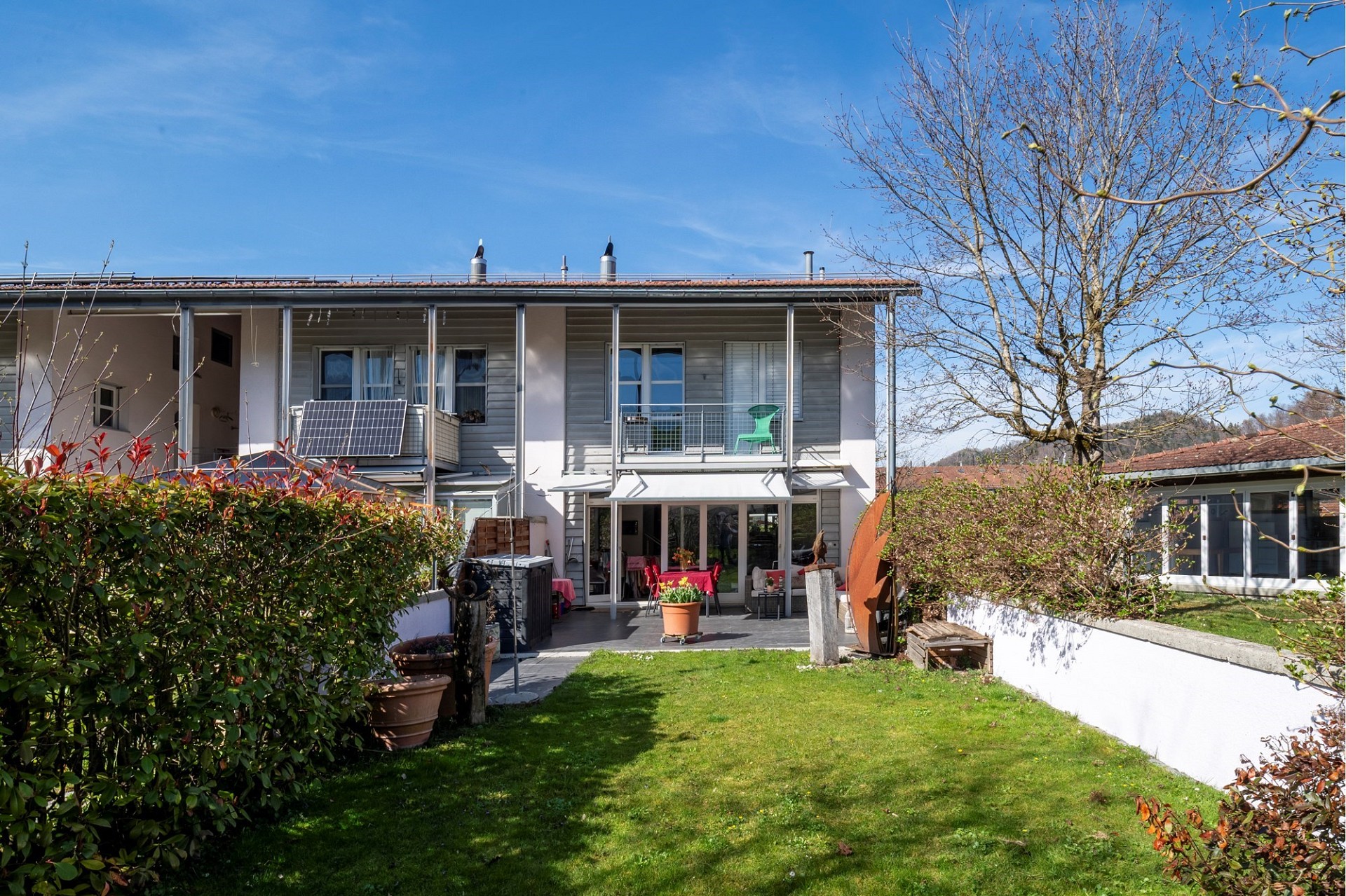 Gartenansicht eines Reihenhauses mit Terrasse und Balkon