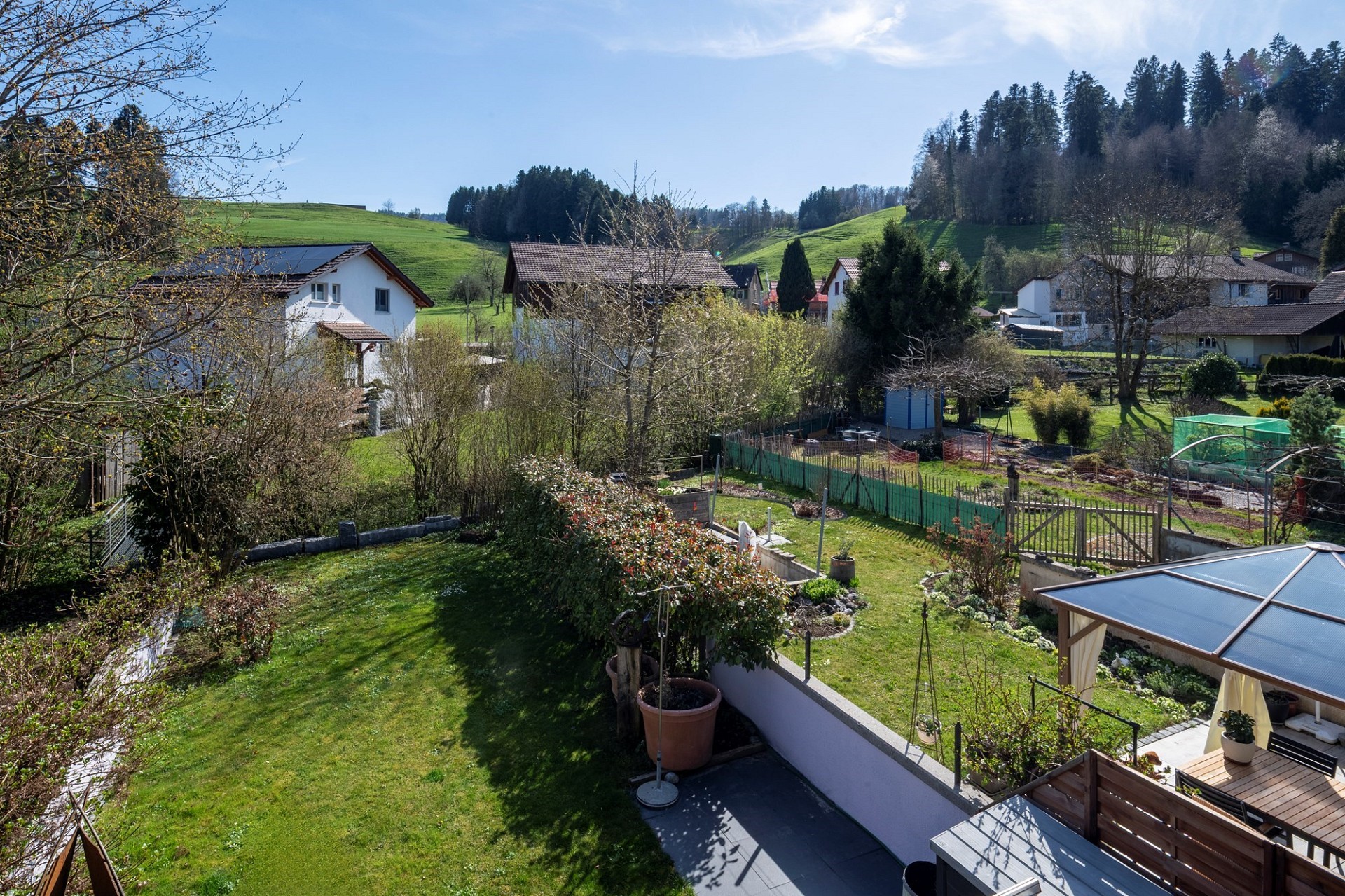 Ländlicher Garten- und Ausblick mit Häusern und Hügeln