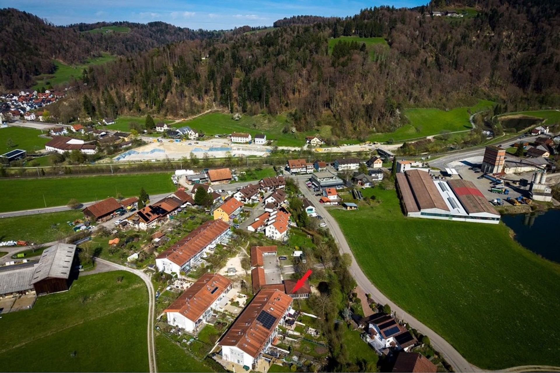 Luftaufnahme eines ländlichen Dorfes mit Gebäuden und grüner Landschaft
