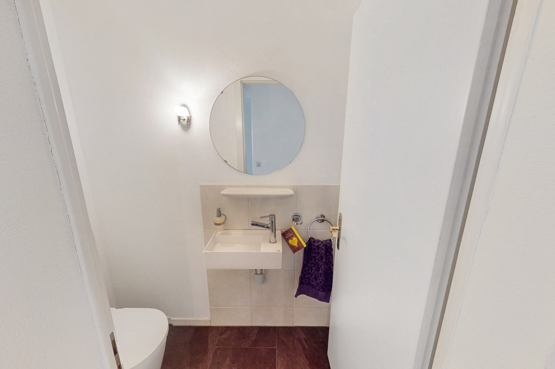 Kleines Gäste-WC mit Waschbecken und Spiegel