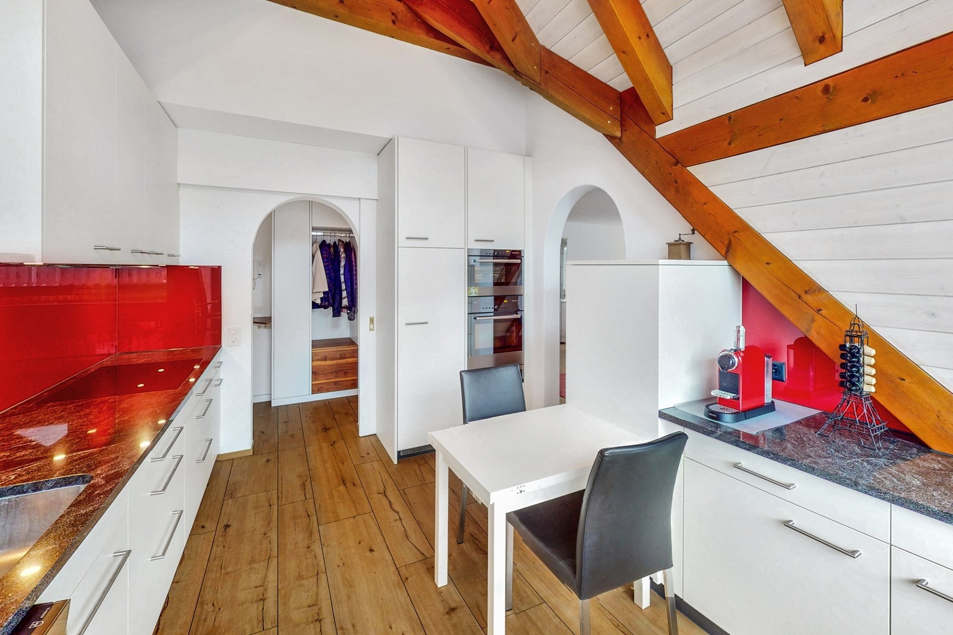 Moderne Küche mit Dachschräge und sichtbaren Holzbalken