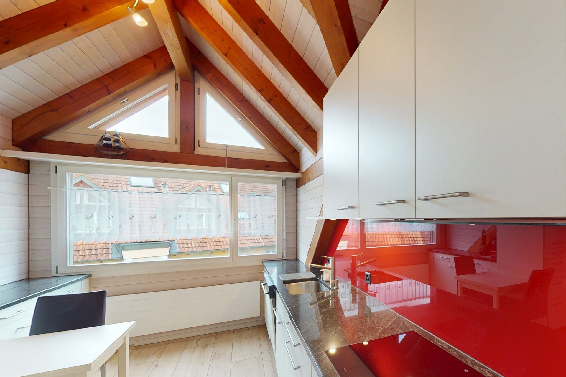 Helle Dachgeschossküche mit sichtbaren Holzbalken
