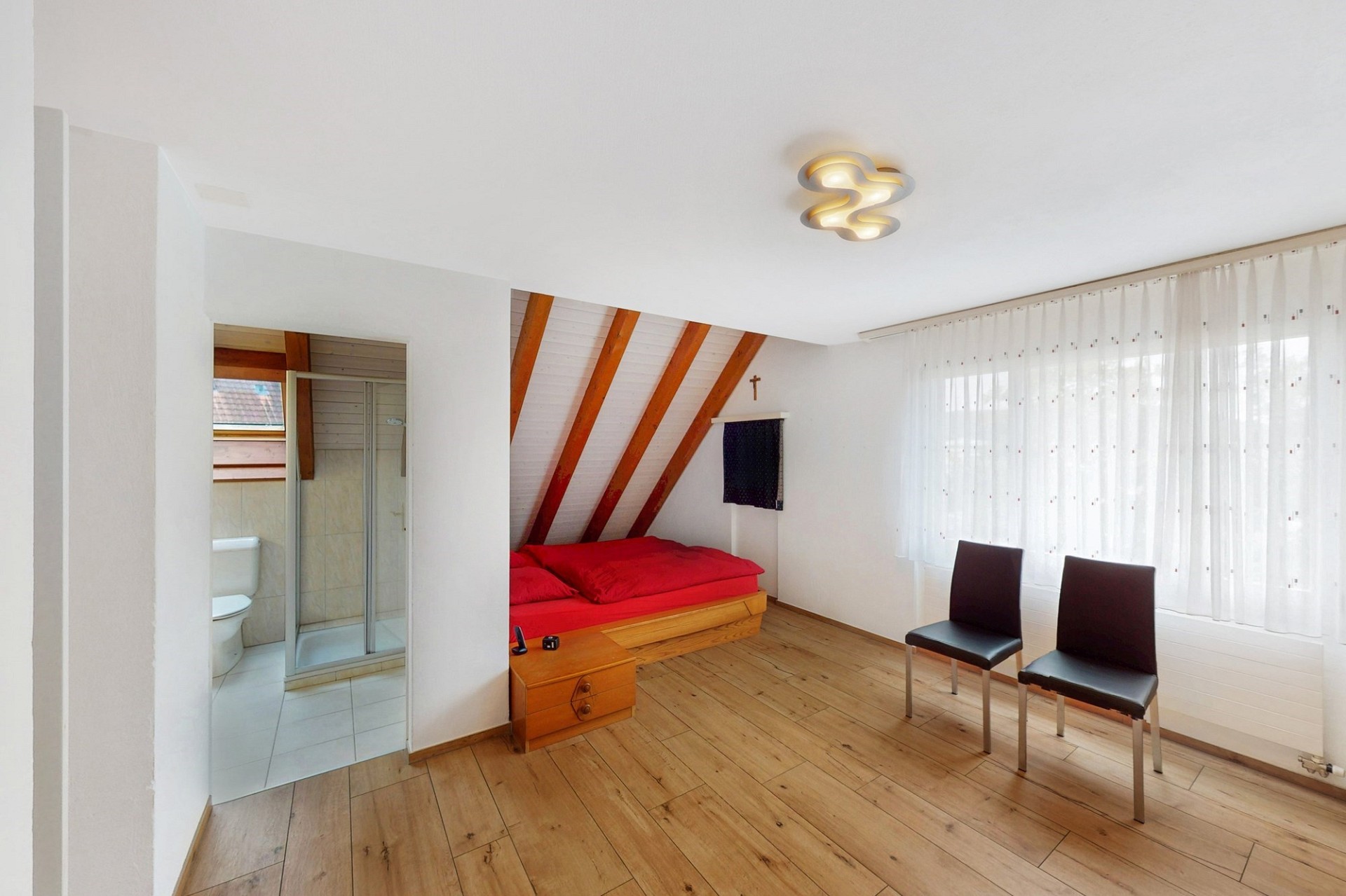 Helles Dachzimmer mit Schlafbereich und Badzugang