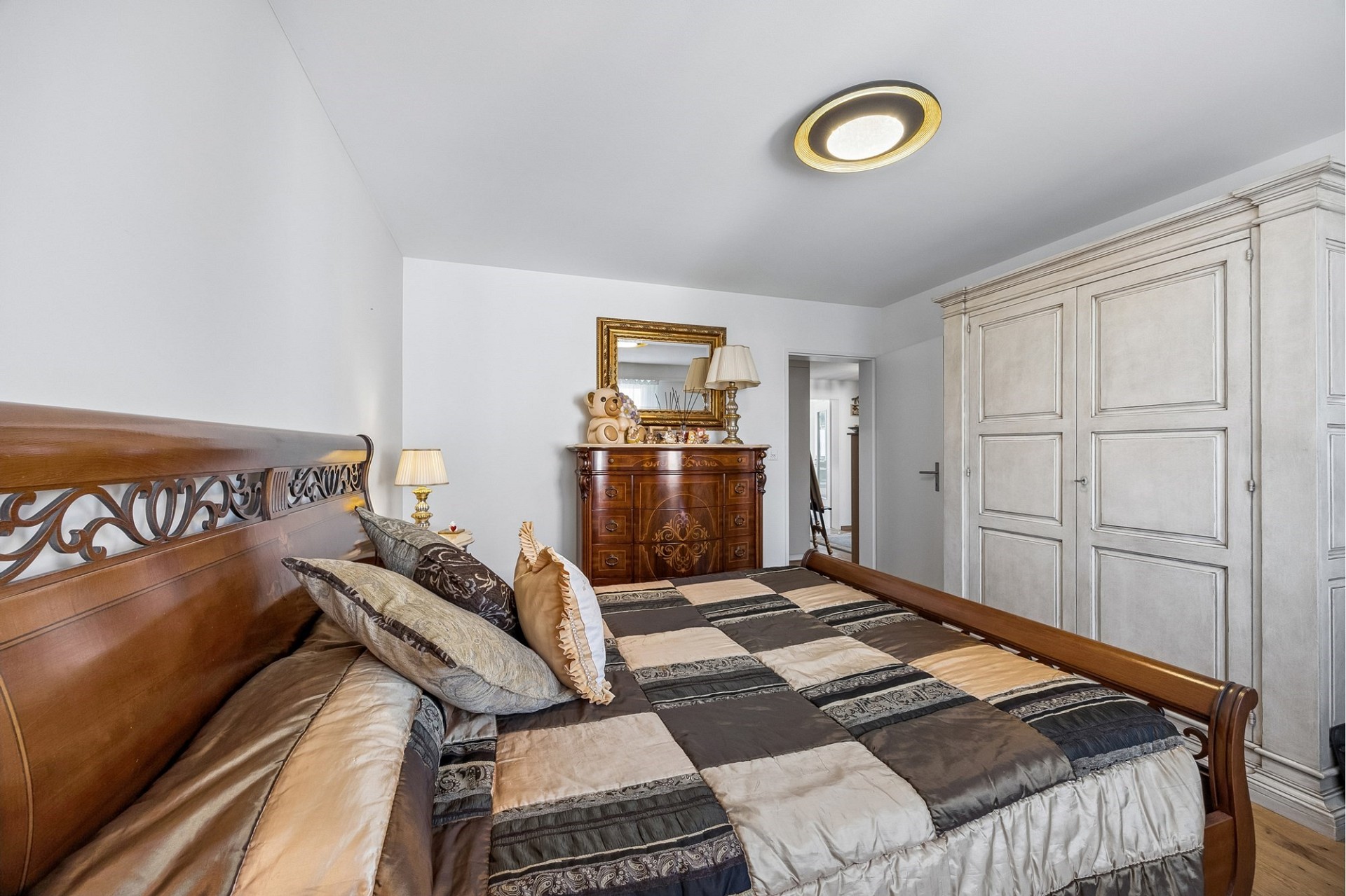 Schlafzimmer mit klassischem Holzbett und Kleiderschrank