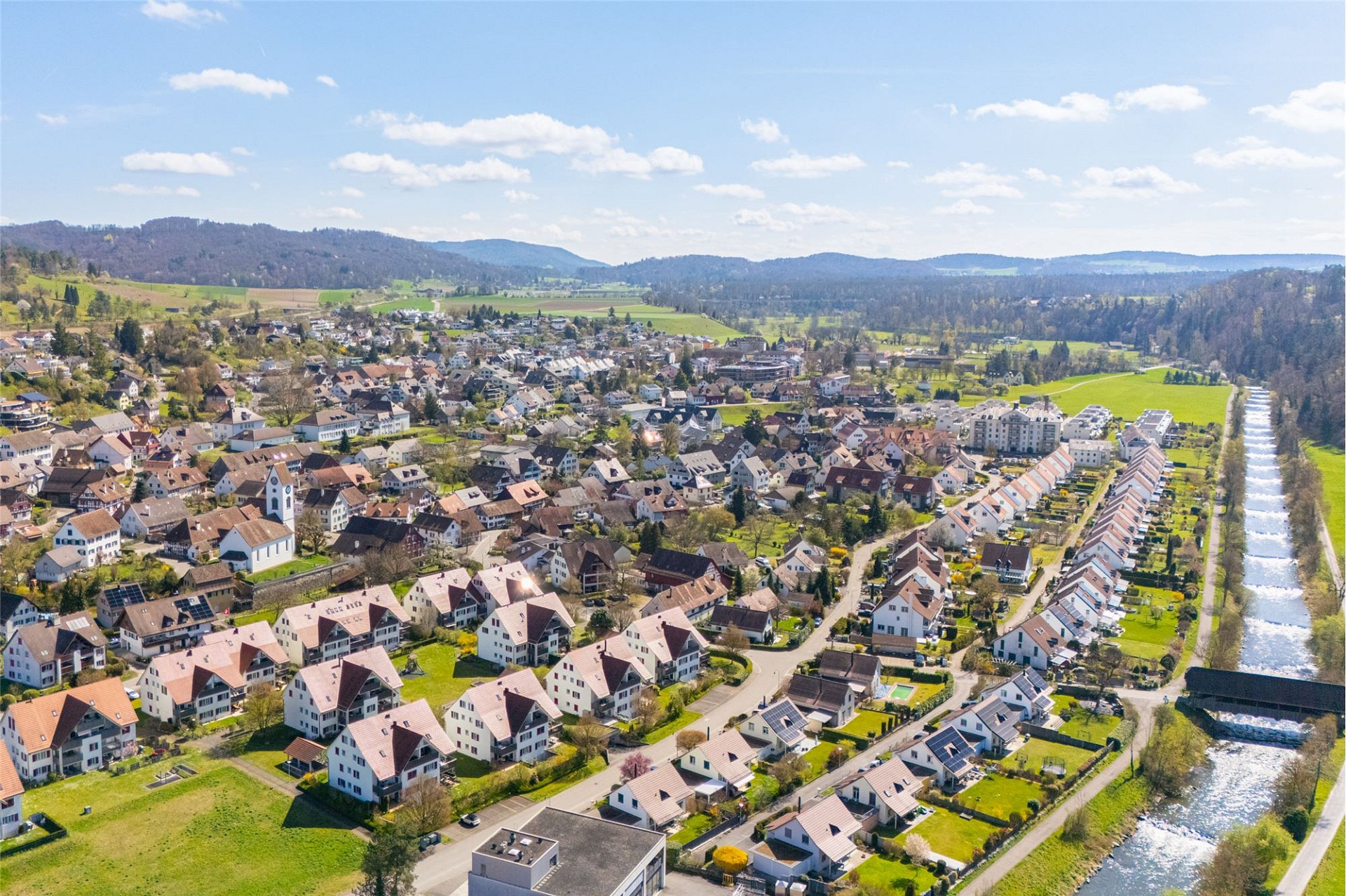 Luftaufnahme einer Wohnsiedlung mit Fluss und Landschaft