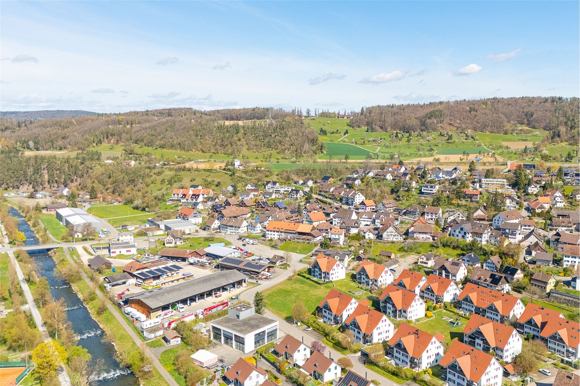Luftaufnahme eines kleinen Ortes mit Wohnhäusern und Fluss