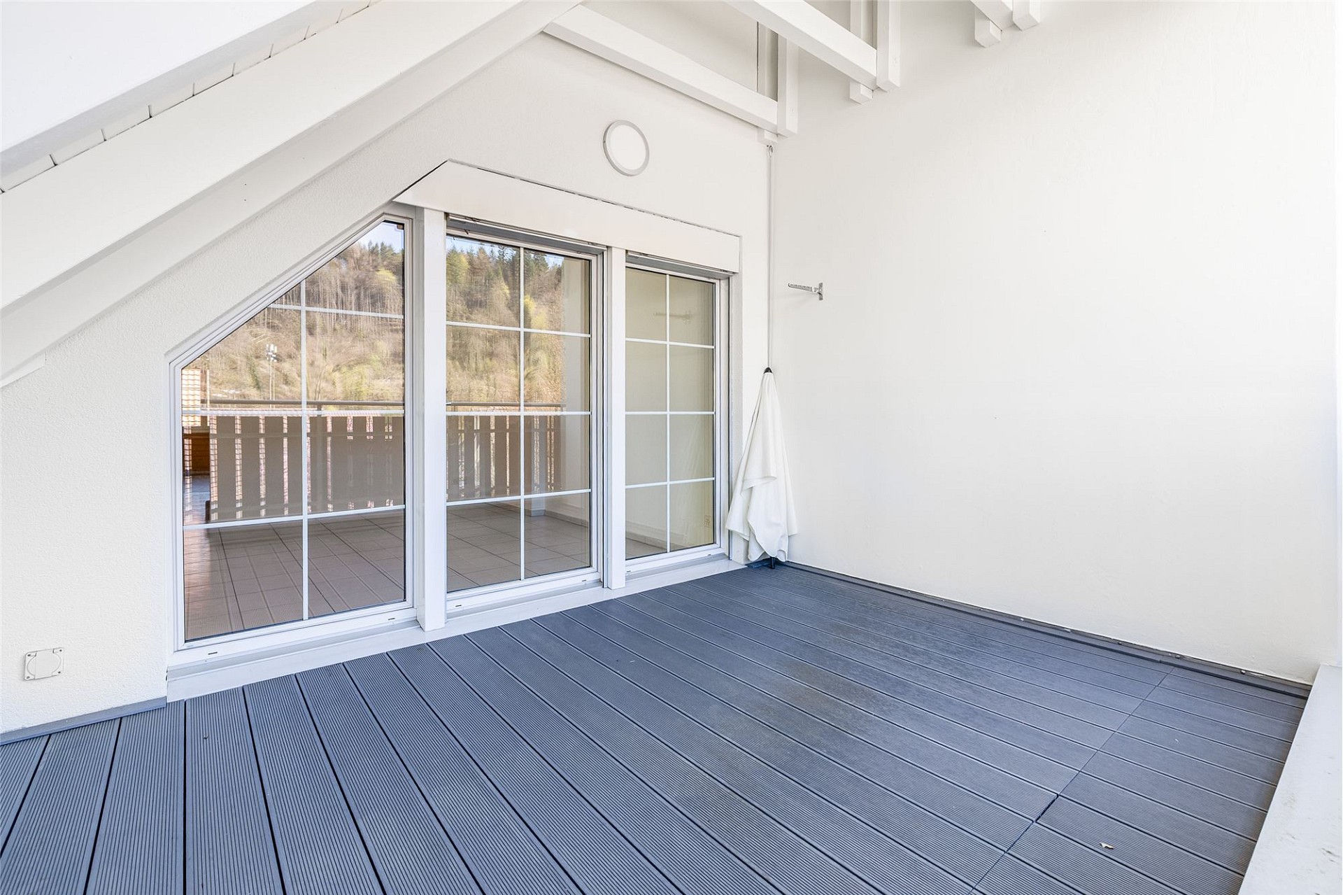 Überdachter Balkon mit großen Schiebetüren