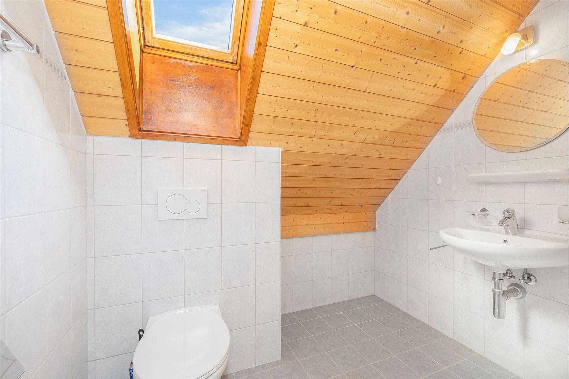 Dachgeschoss-Badezimmer mit WC und Waschbecken