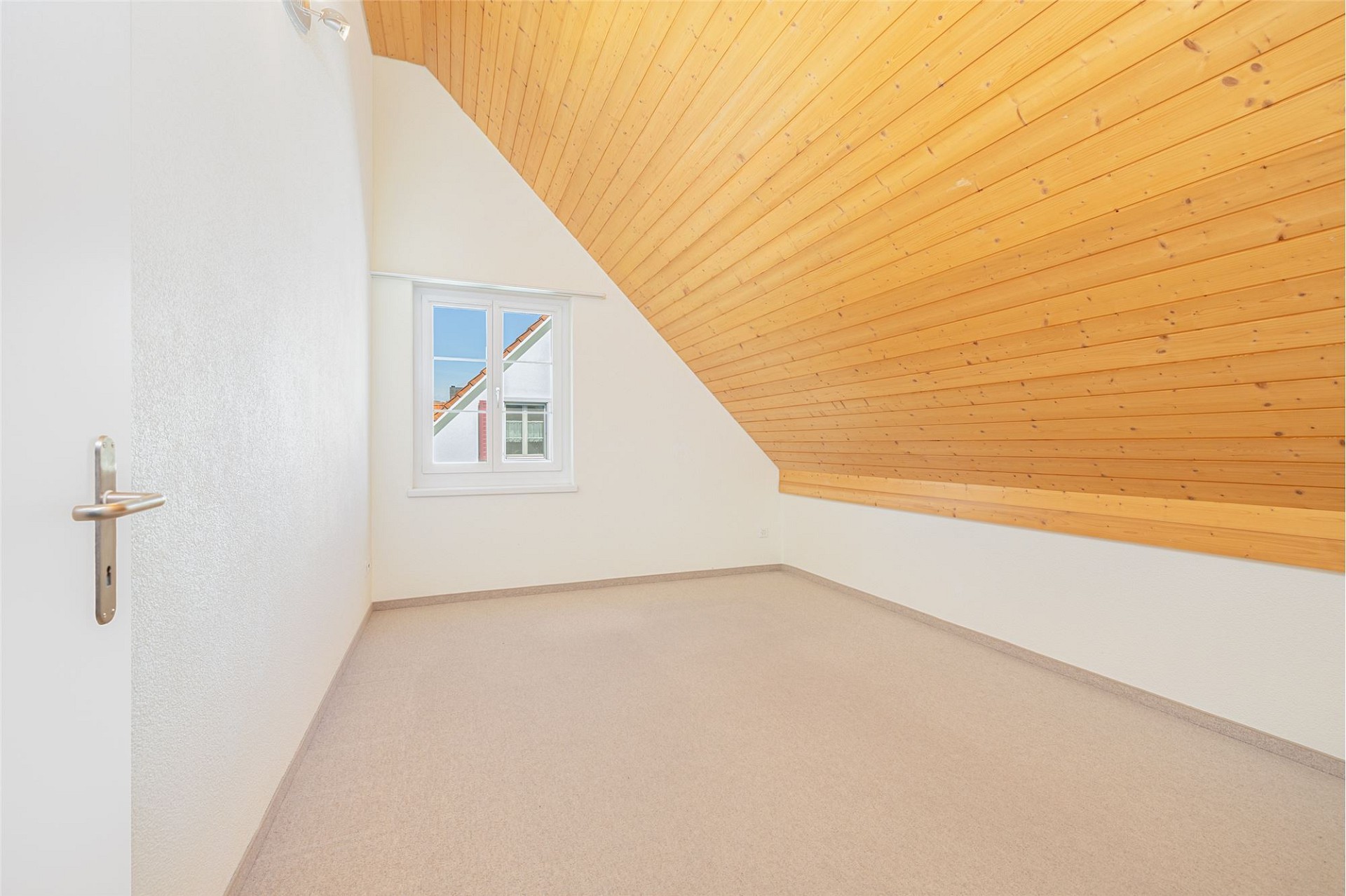 Dachzimmer mit schräger Holzdecke