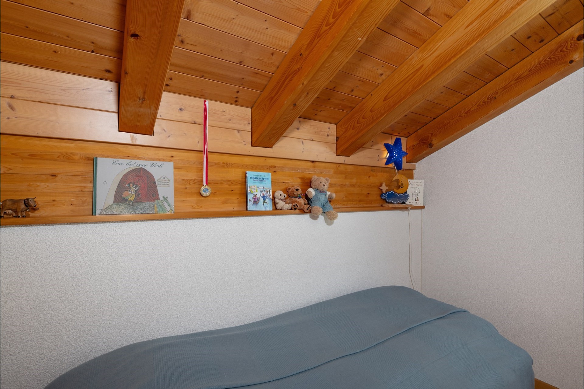 Gemütliches Dachzimmer mit Holzbalken und Kinderdekoration