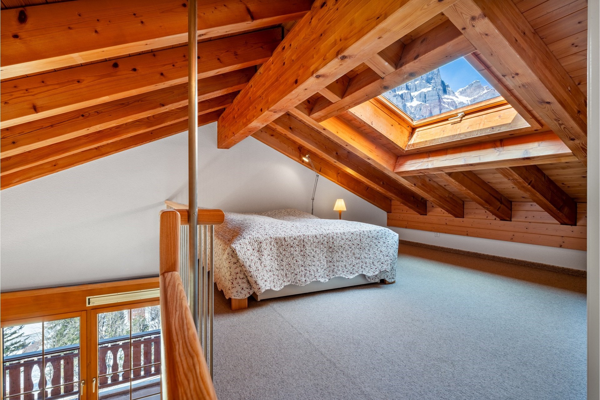 Dachgeschoss-Schlafzimmer mit Holzbalken und Dachfenster