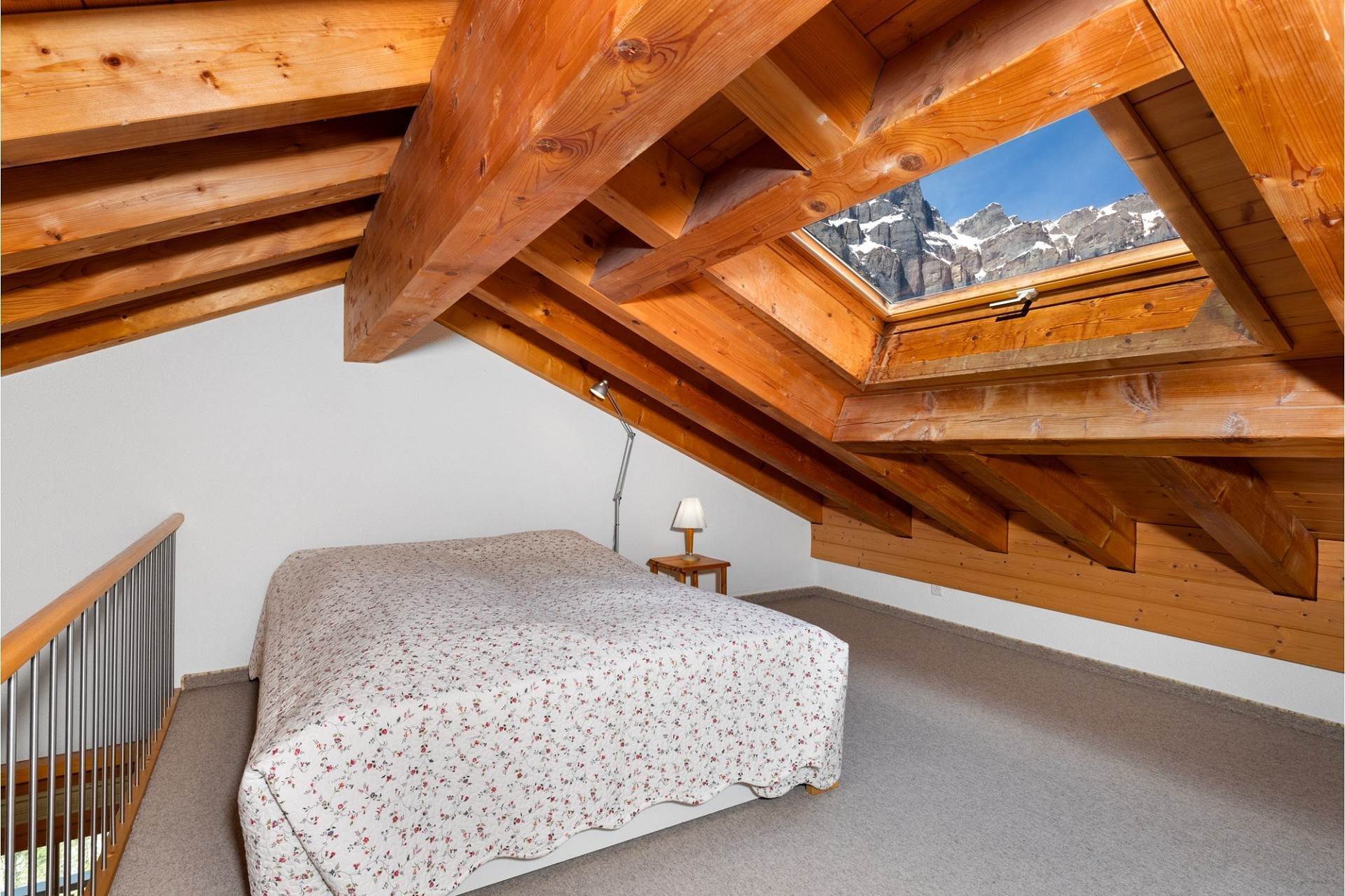 Dachgeschoss-Schlafzimmer mit Holztragwerk und Dachfenster