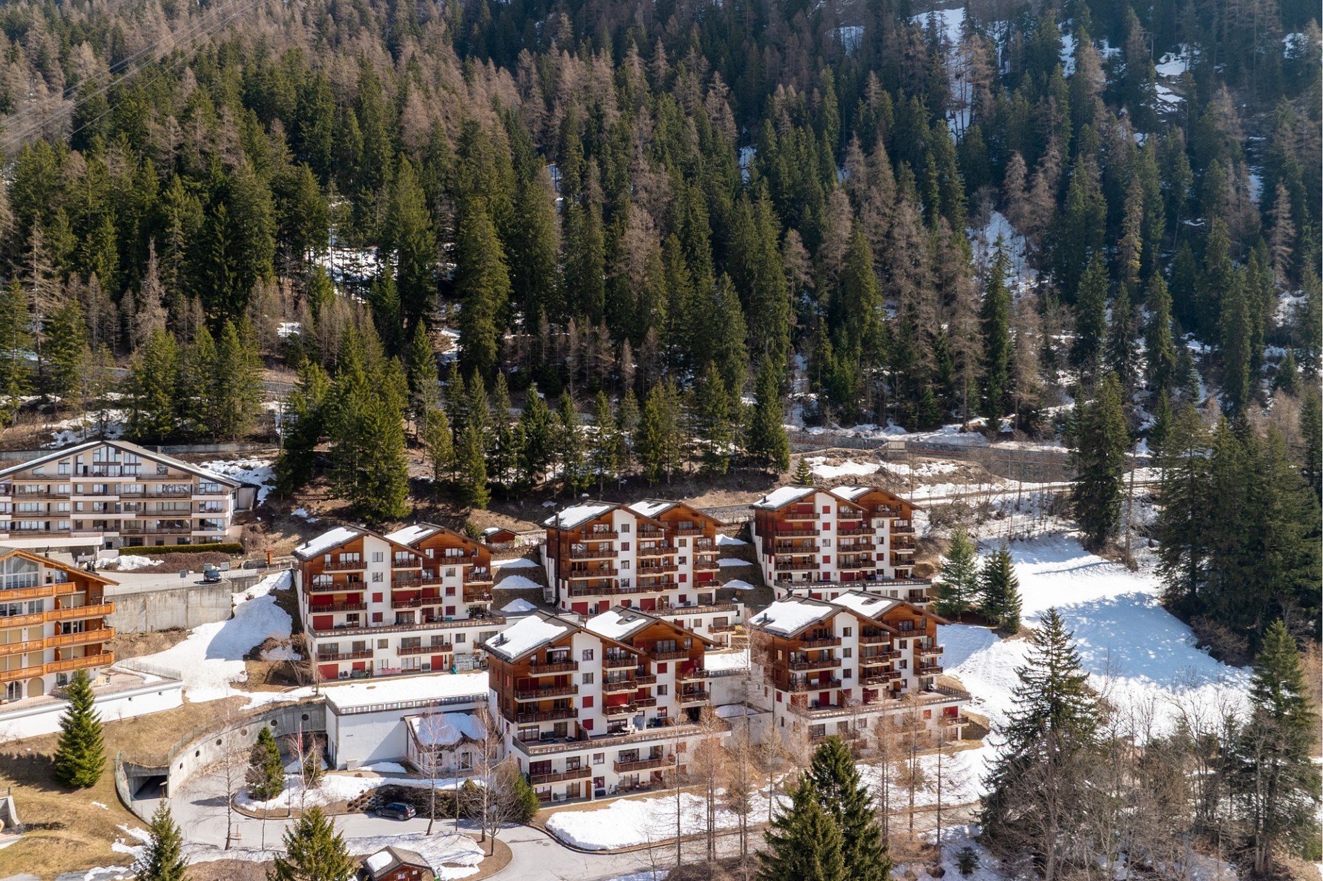 Luftaufnahme einer alpinen Ferienwohnanlage im Schnee