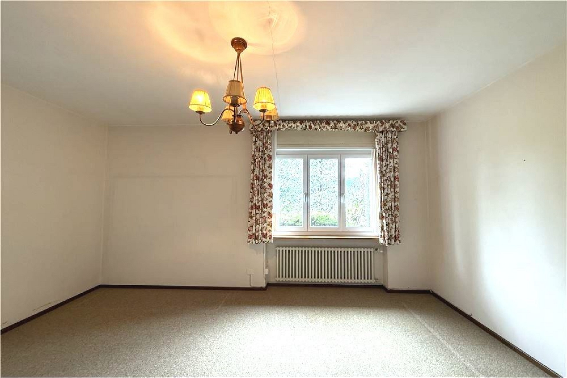 Leerer Wohnraum mit Fenster und Heizung