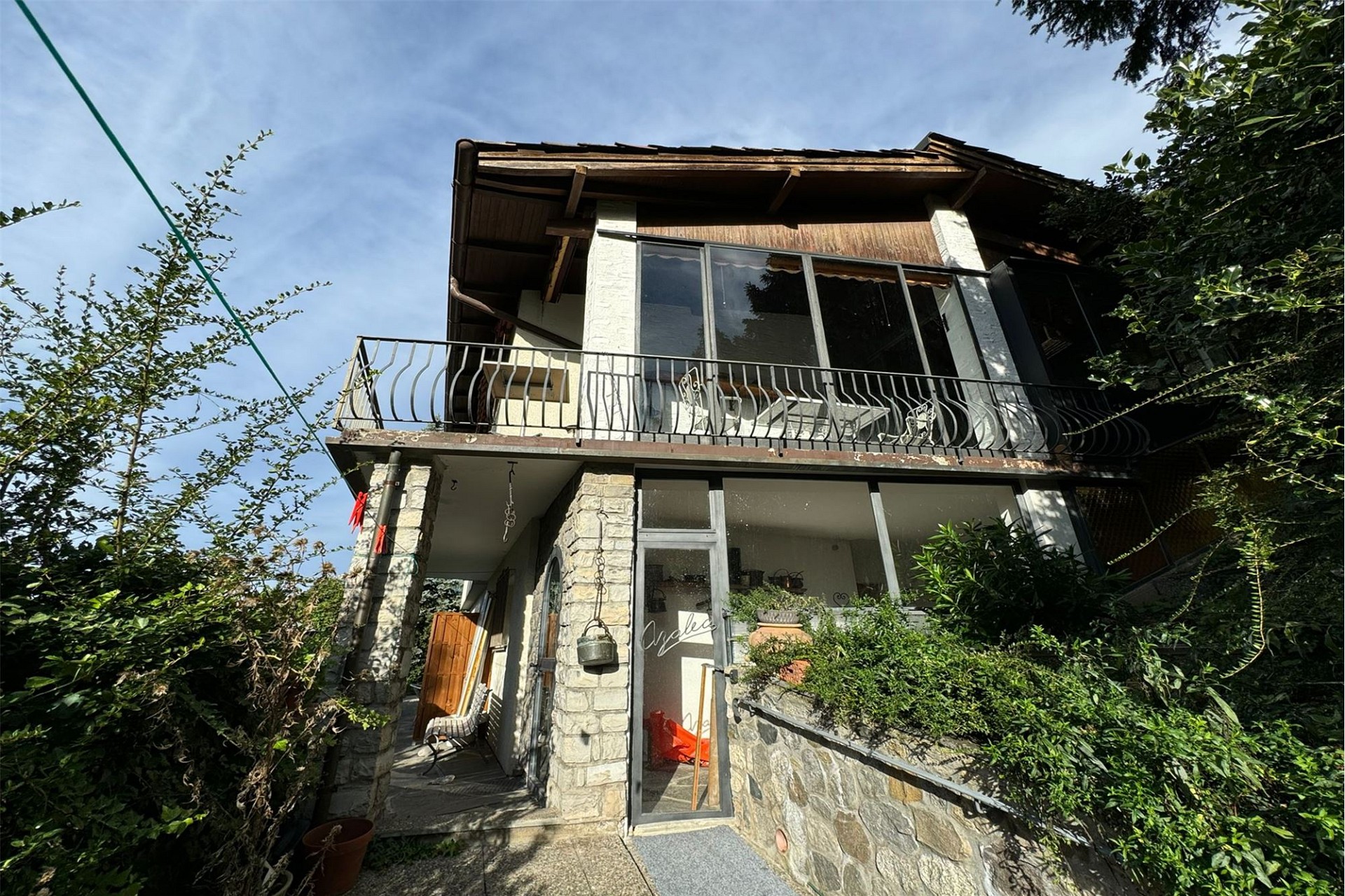 Gartenansicht eines rustikalen Hauses mit Balkon