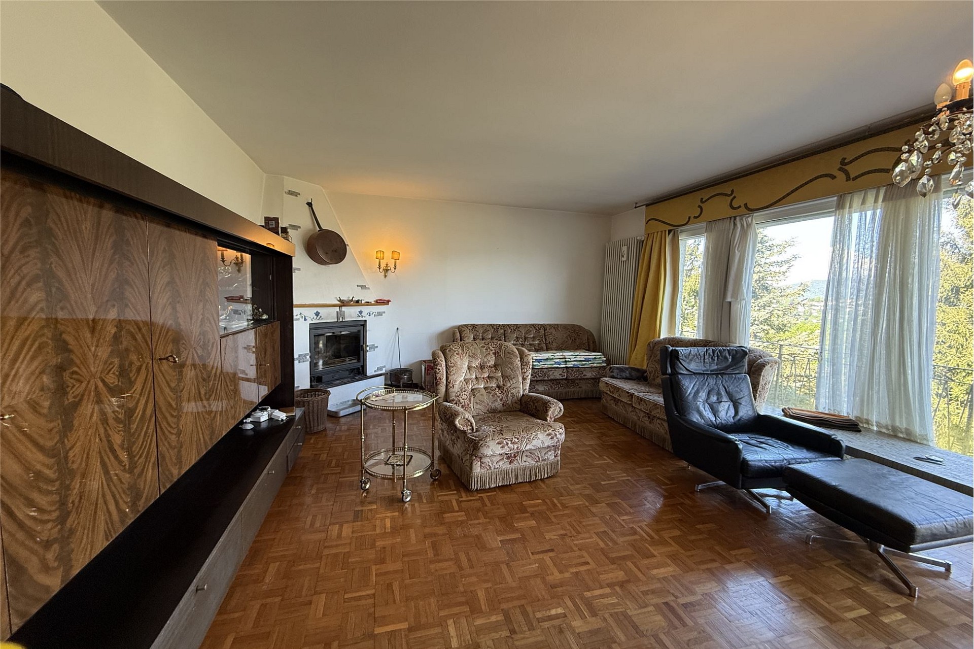 Wohnzimmer mit Kamin und Balkonblick