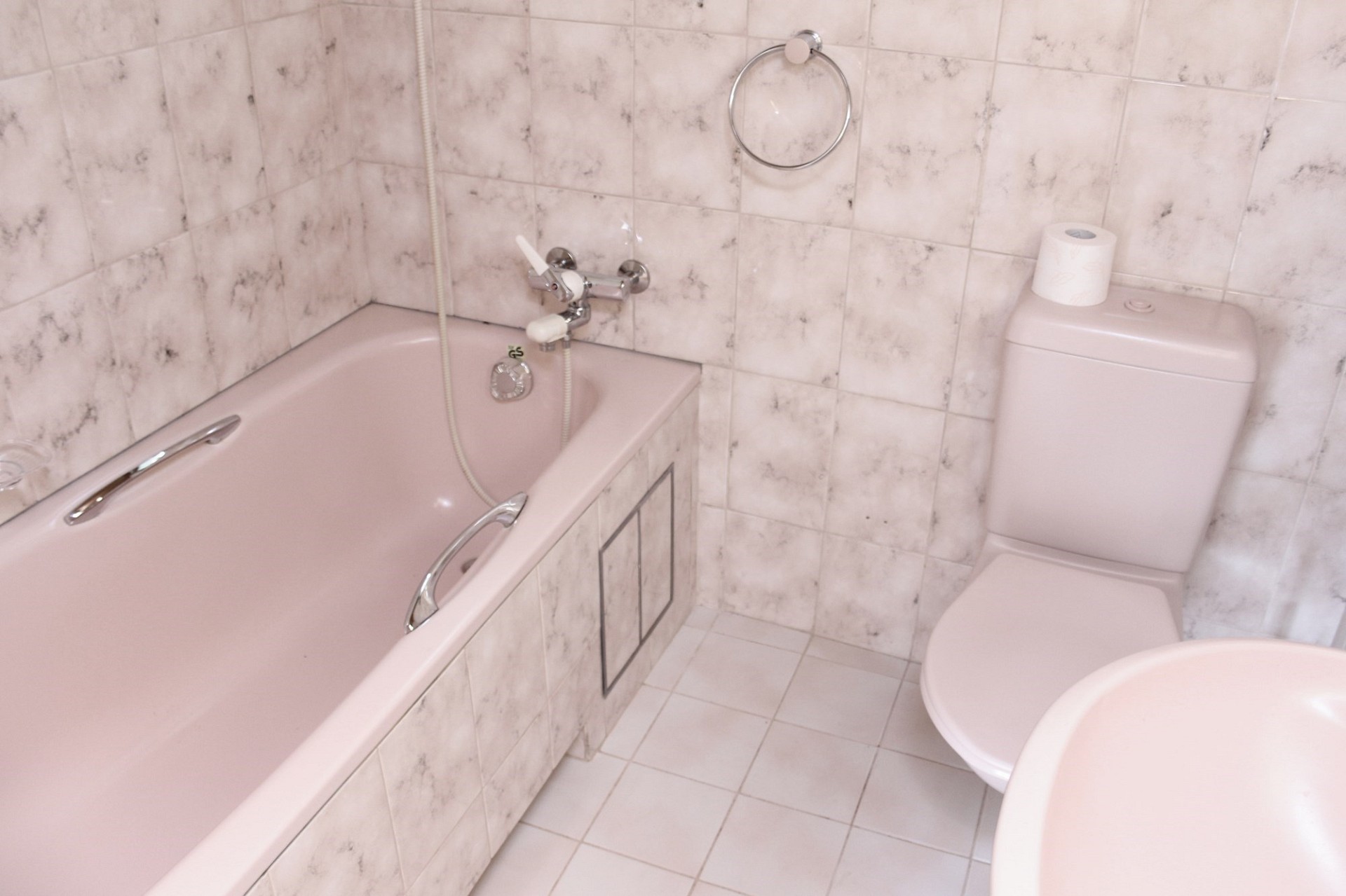 Pastellfarbenes Badezimmer mit Badewanne und WC
