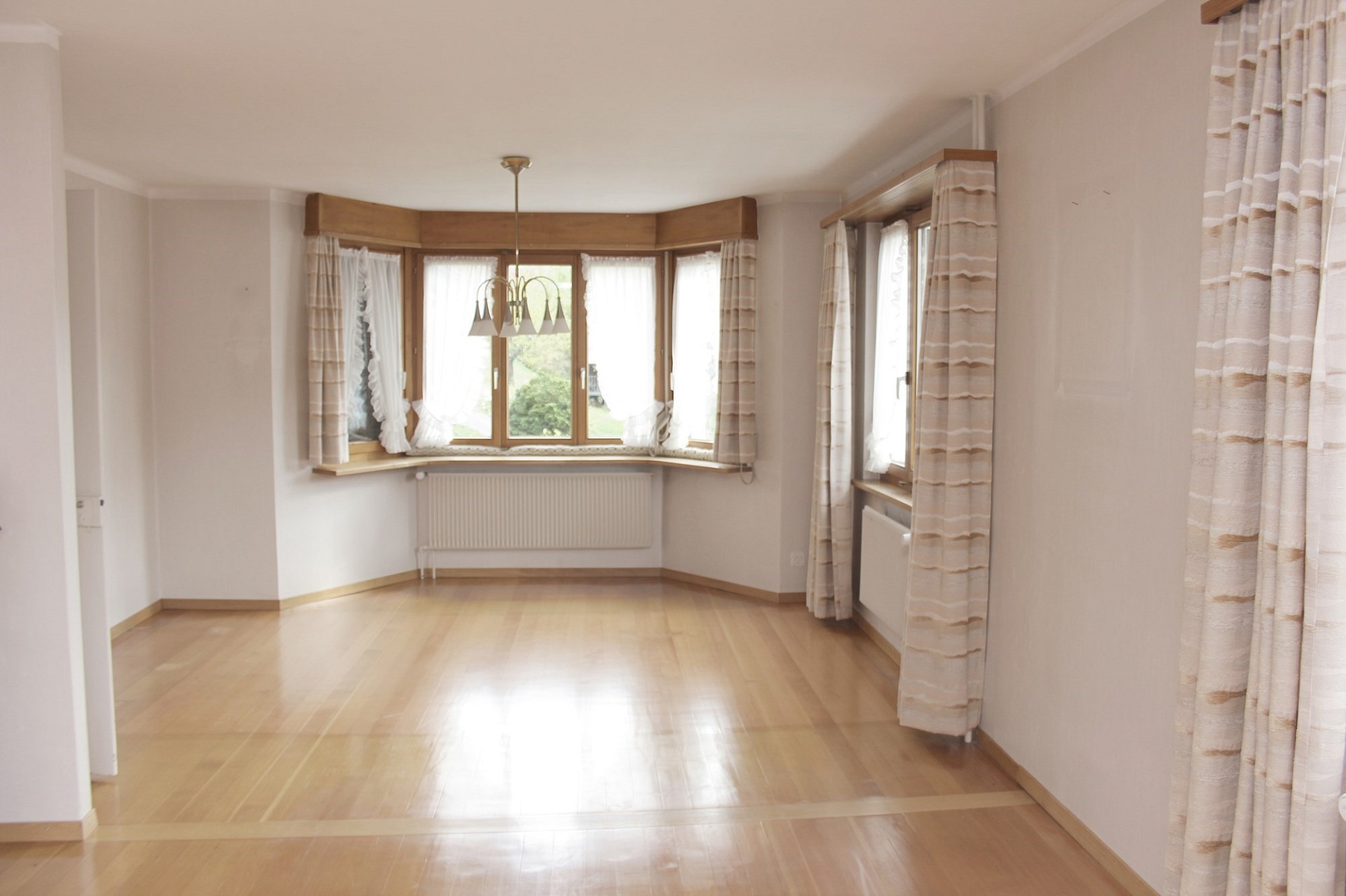 Helles, leeres Wohn-/Esszimmer mit Erkerfenstern