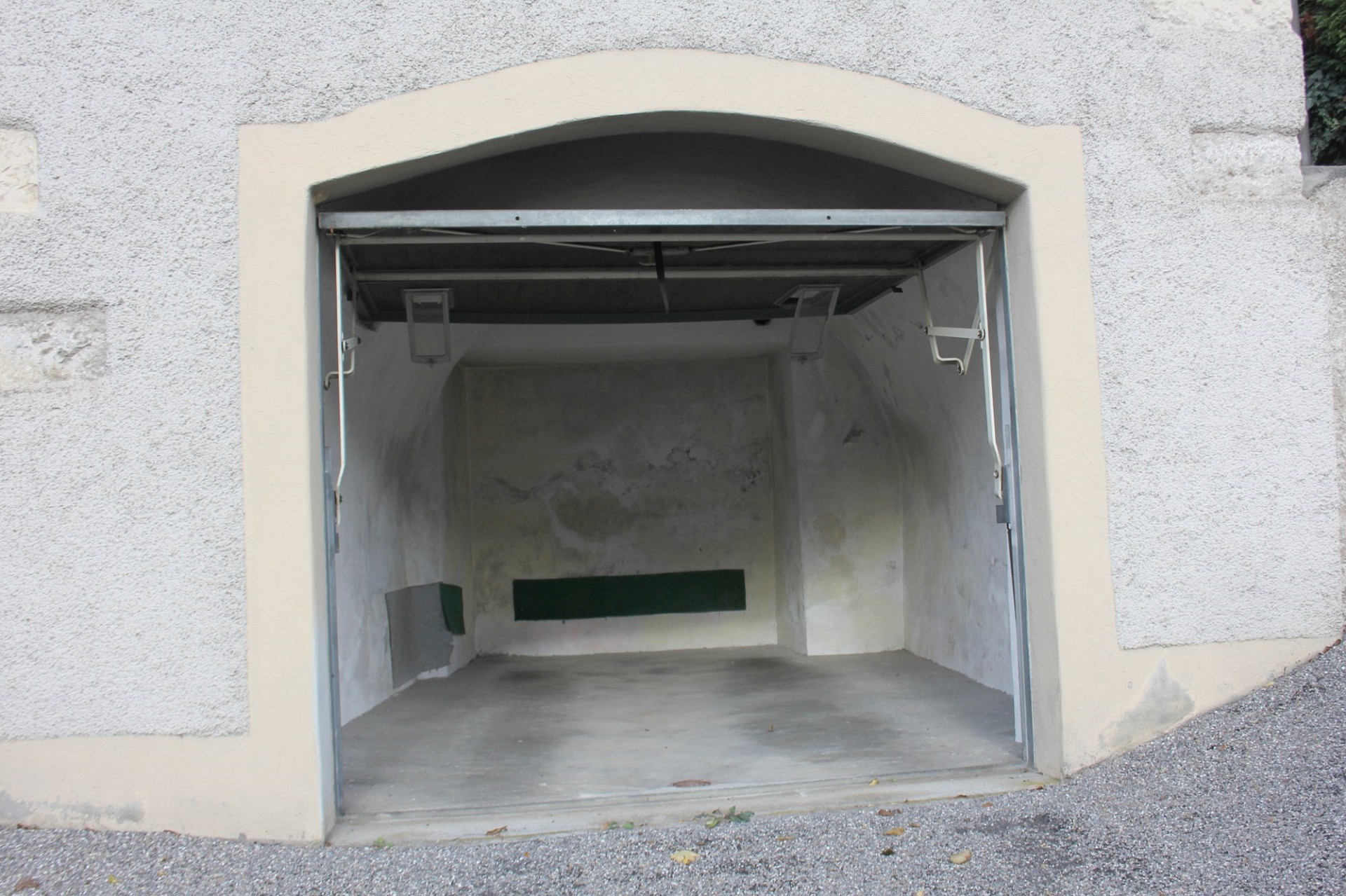 Offene Garage mit sichtbaren Feuchtigkeitsspuren