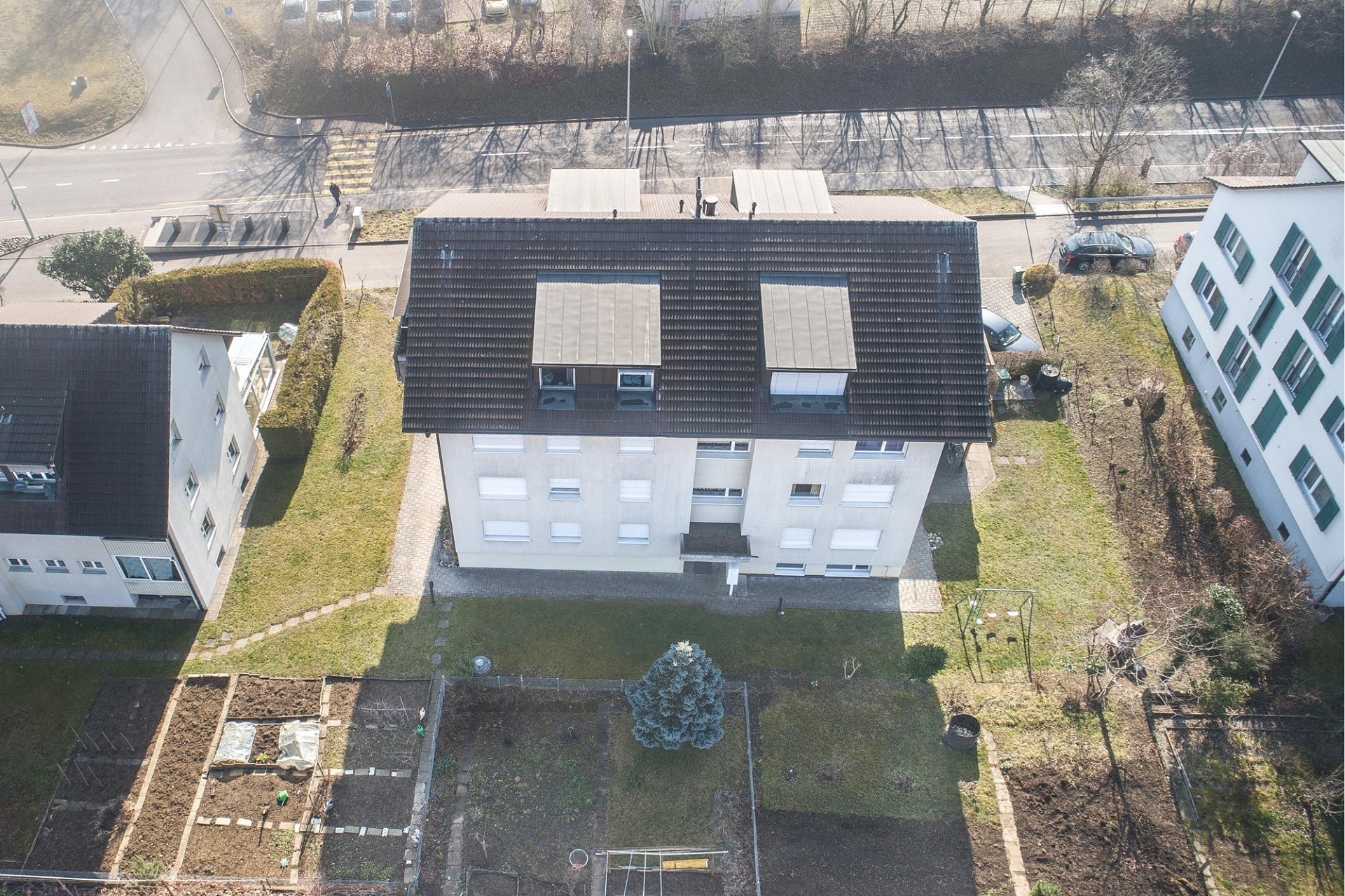 Luftaufnahme eines Mehrfamilienhauses mit Garten