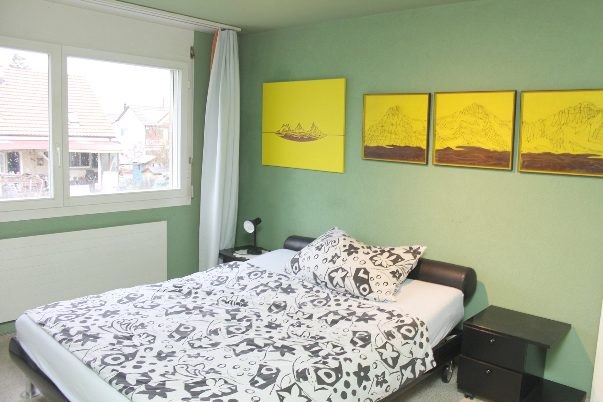 Helles Schlafzimmer mit grünem Wandanstrich