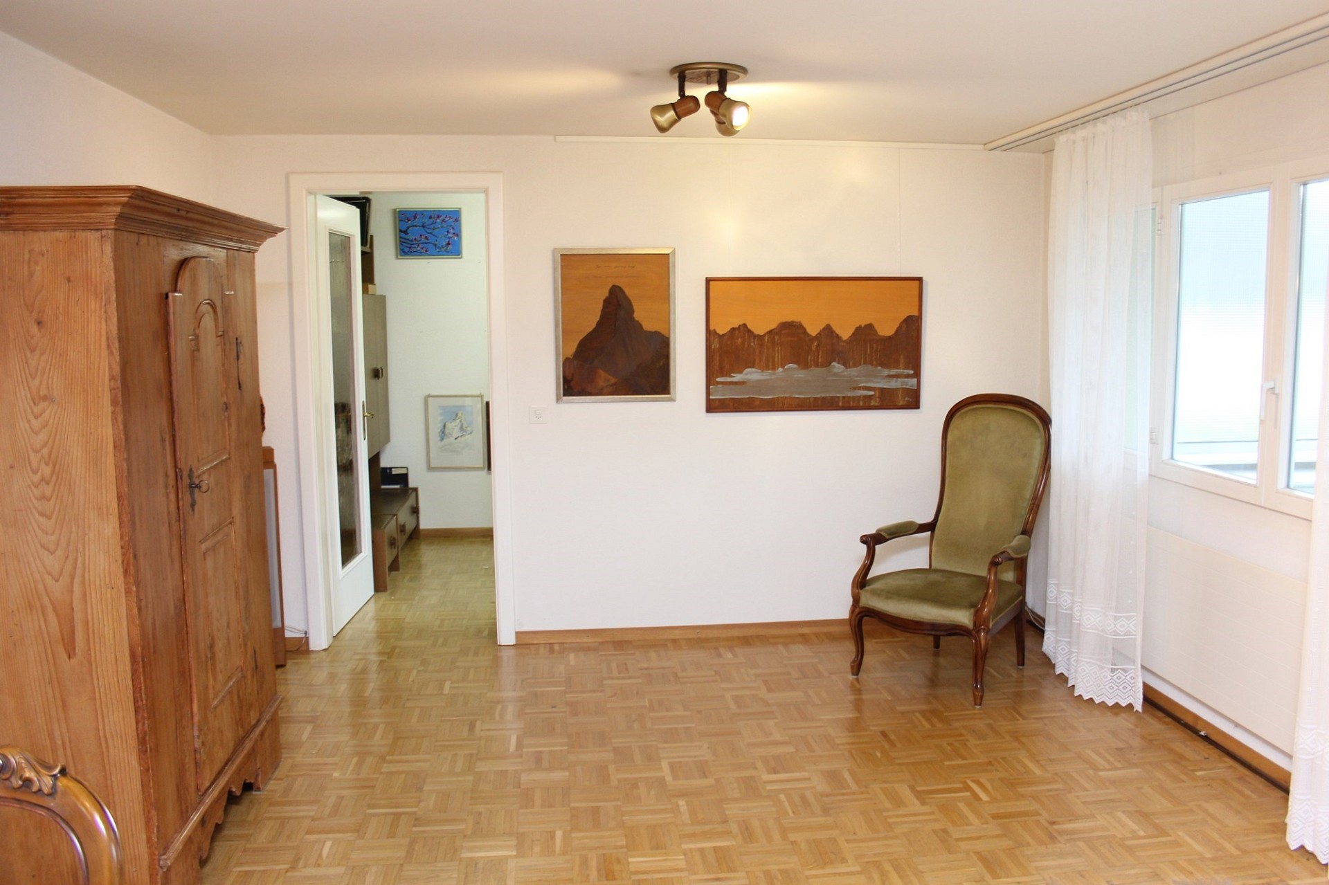 Helles Zimmer mit Holzboden und antiken Möbeln