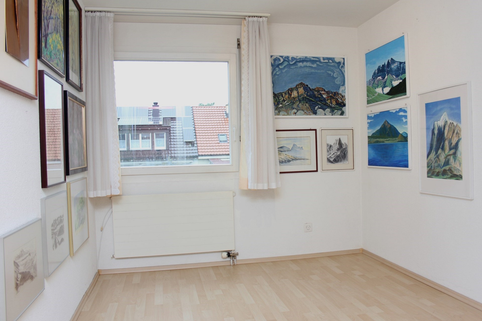 Helles Zimmer mit Kunstwerken und Fensterblick