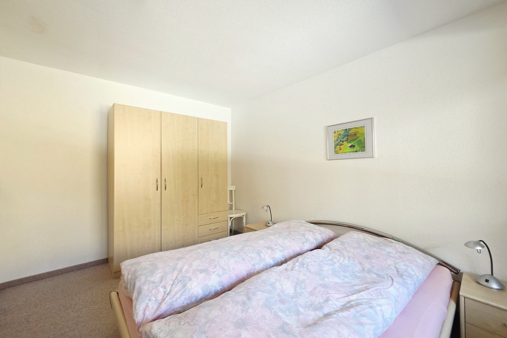 Helles Schlafzimmer mit Doppelbett und Kleiderschrank