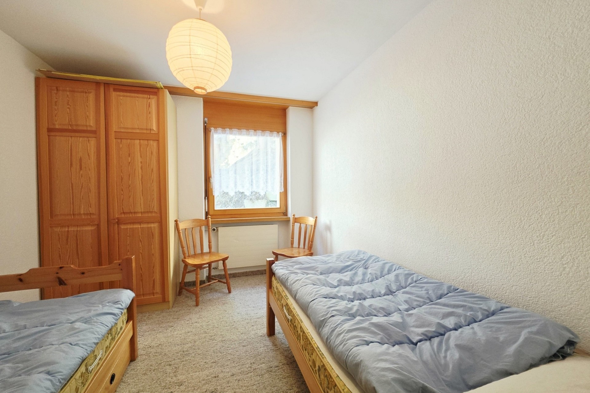 Zweibettzimmer mit Holzmöbeln