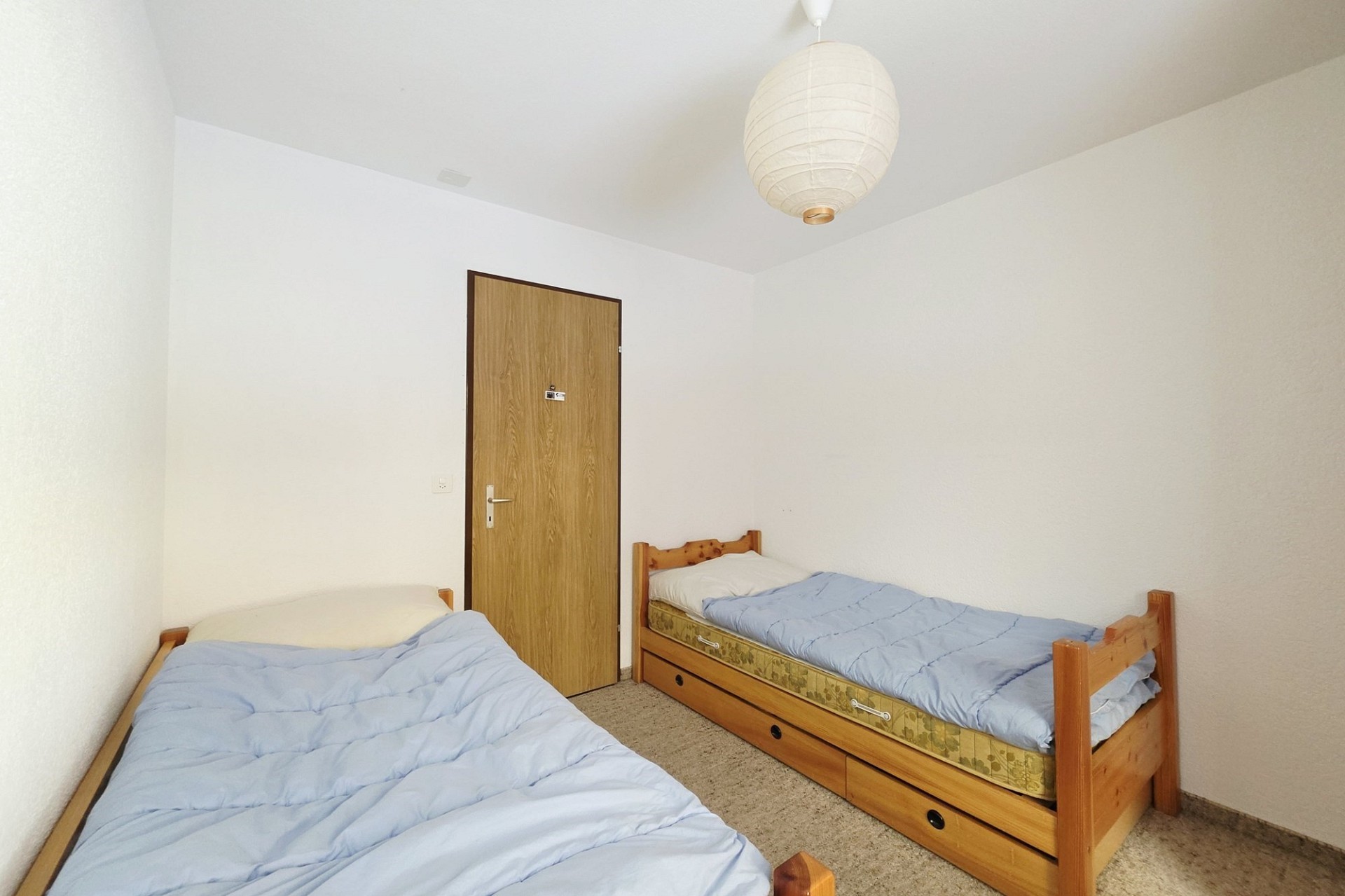 Einfaches Schlafzimmer mit zwei Einzelbetten