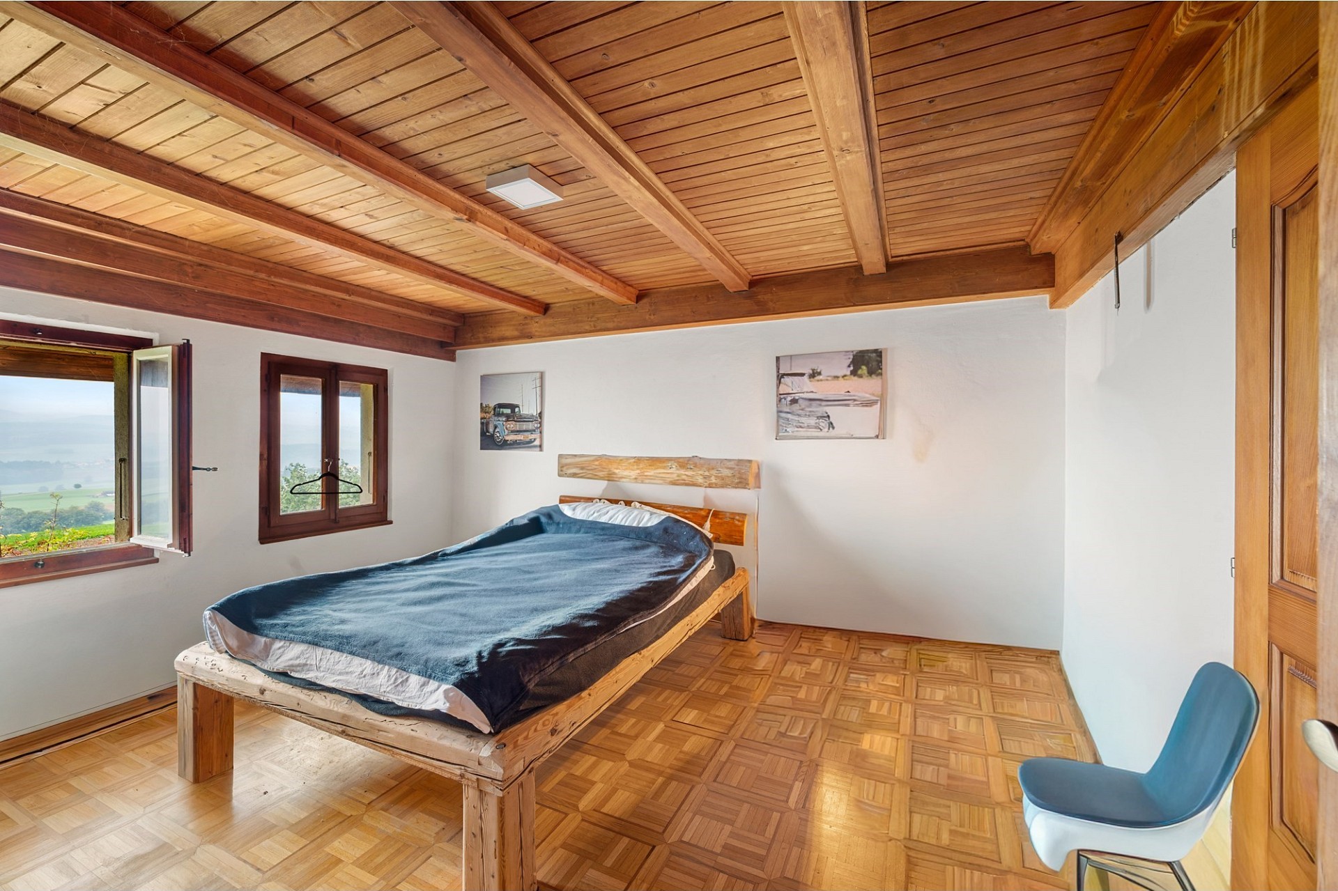 Schlafzimmer mit Holzdecke und Blick ins Grüne