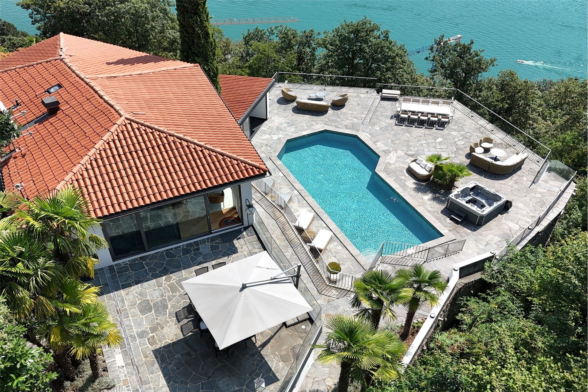 Luxuriöse Außenansicht einer Villa mit Poolterrasse am Wasser