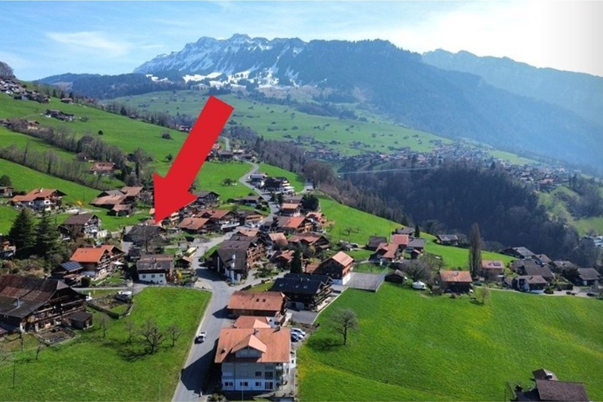Luftaufnahme eines alpinen Dorfes mit Bergpanorama
