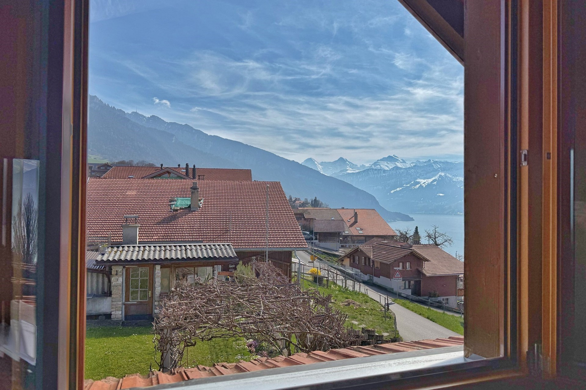Ausblick aus einem Fenster auf See und Berge