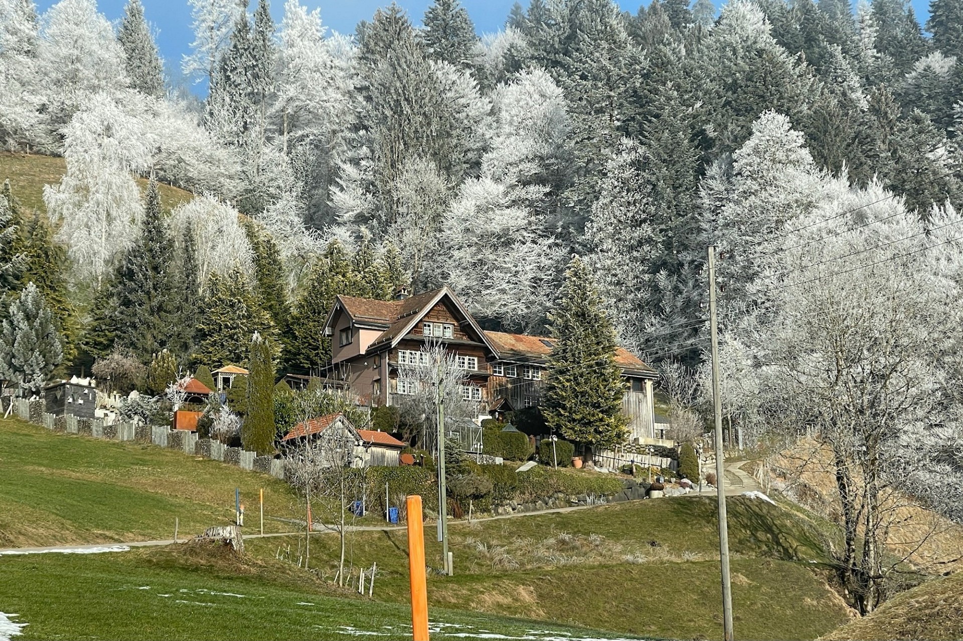Alpines Wohnhaus in winterlicher Hügellandschaft