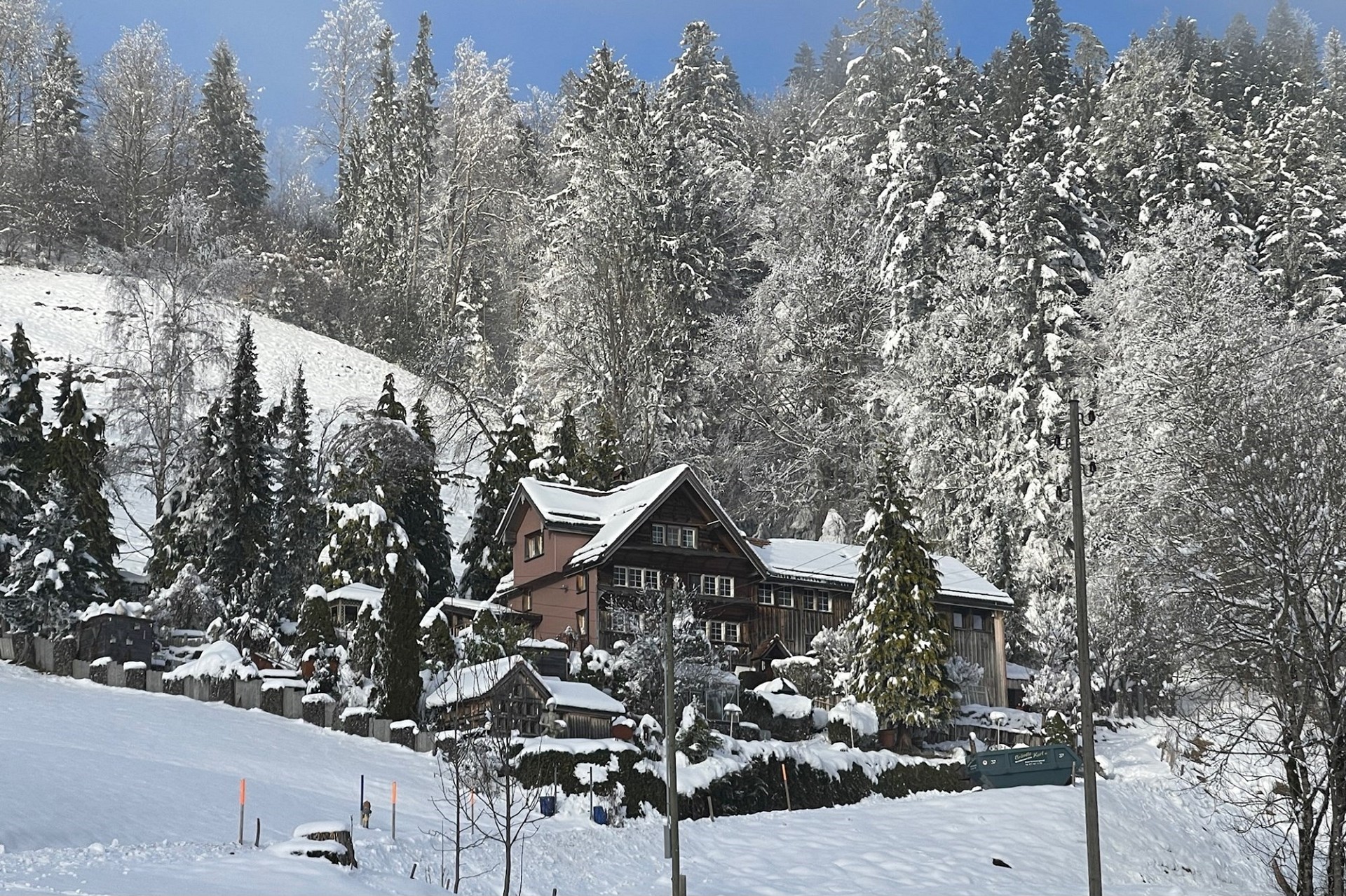 Verschneites Haus in alpiner Hanglage